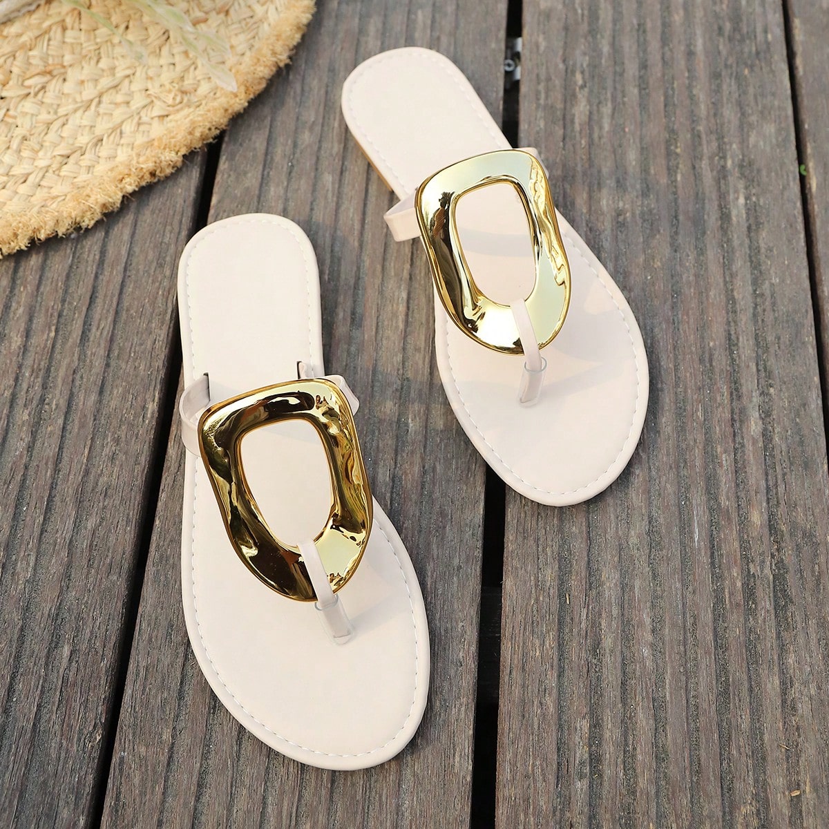Women’s gold flat slide sandals with open toe post design and metal buckle detail, shown as fashionable outdoor summer footwear.