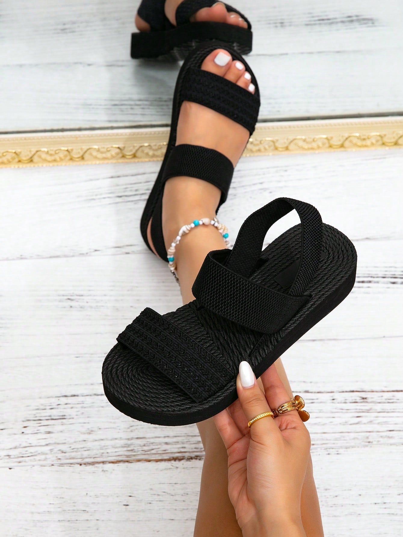 Women's black flat gladiator sandals with ruched and ruffle trim, textured fabric upper, and open-toe design for party, outdoor, and casual wear.