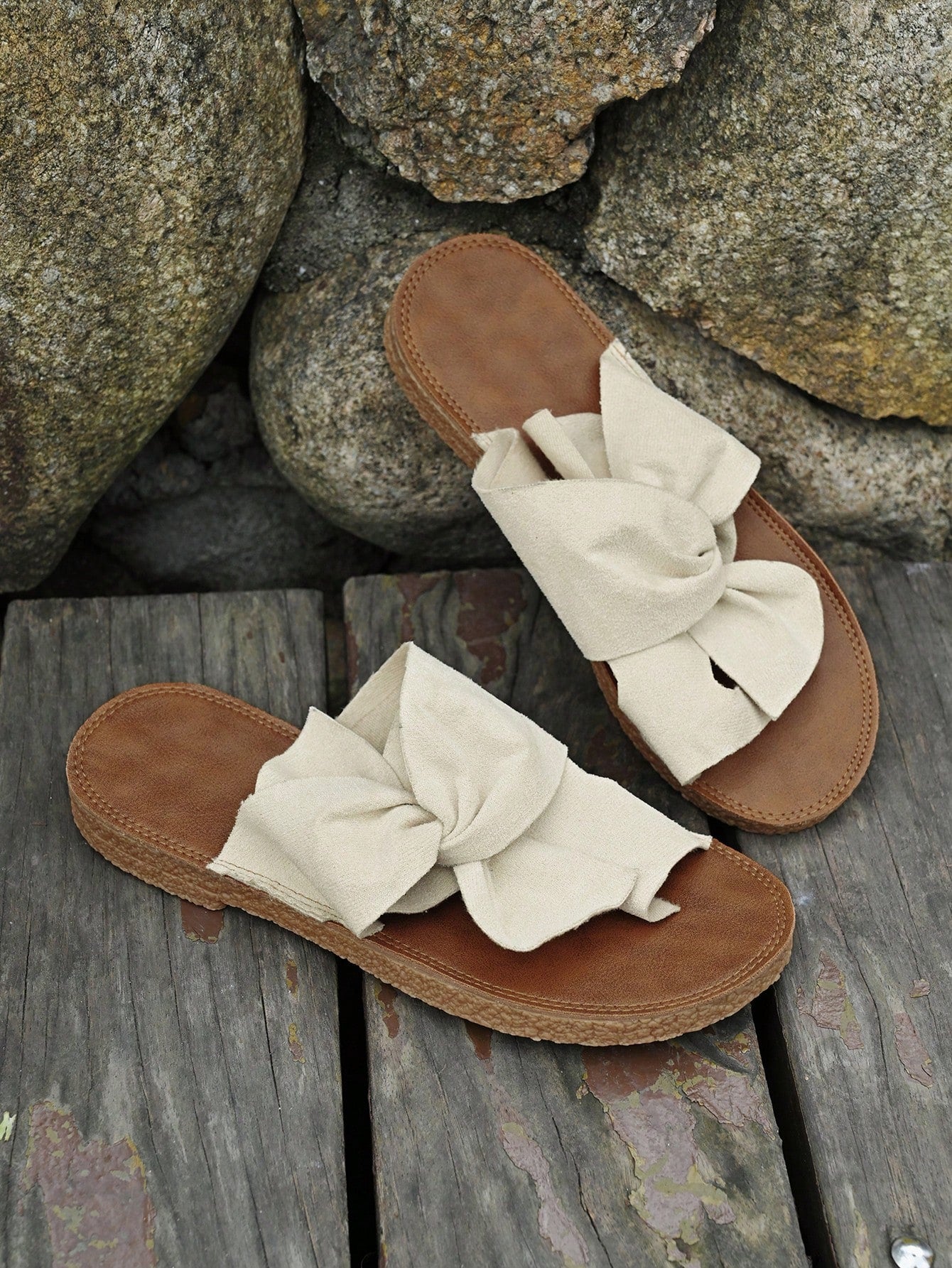 Women's flat slide sandals with bow tie, knot, and braided details, toe post design, and bohemian plant pattern.