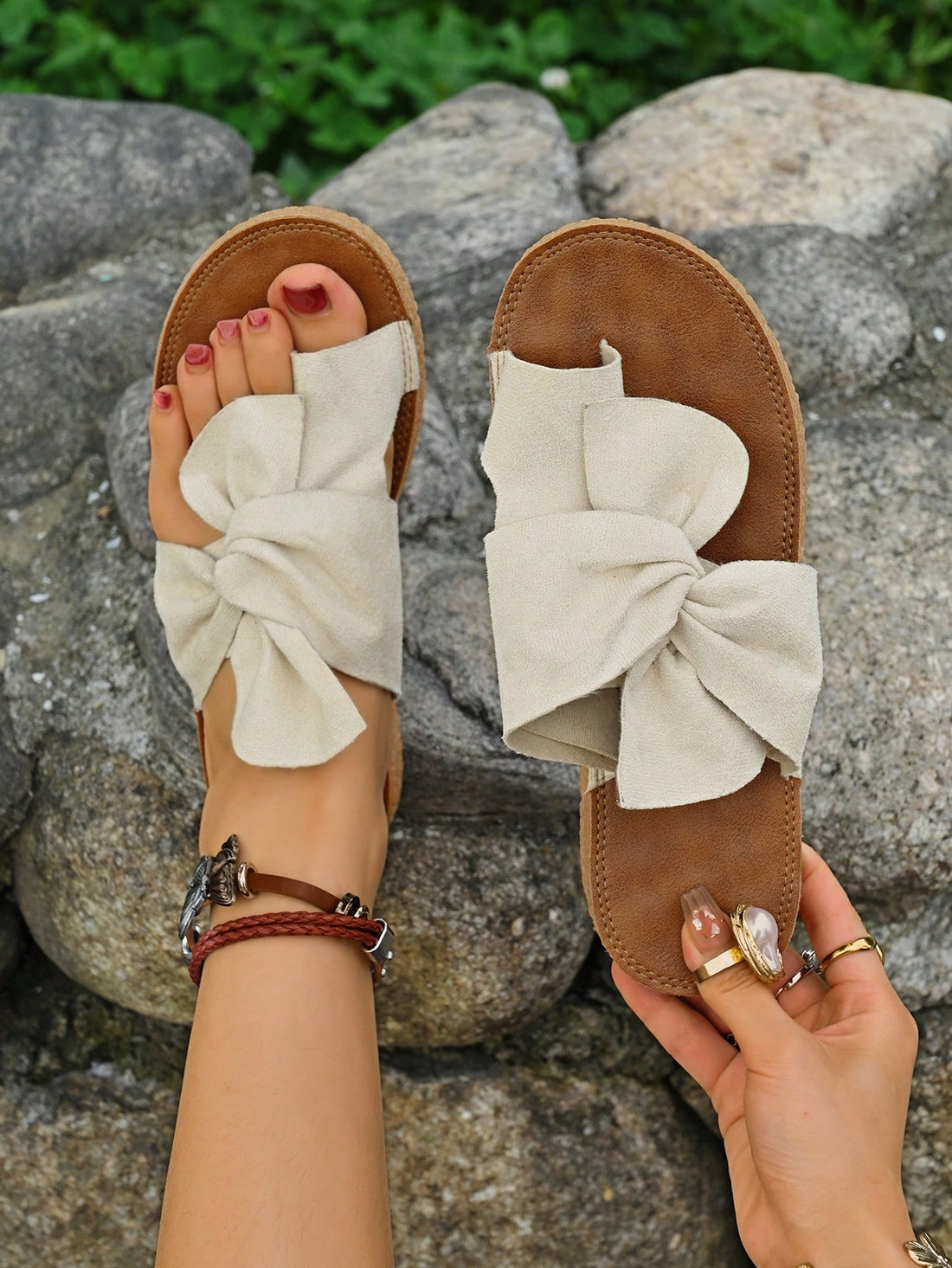 Women's flat slide sandals with bow tie, knot, and braided details, toe post design, and bohemian plant pattern.