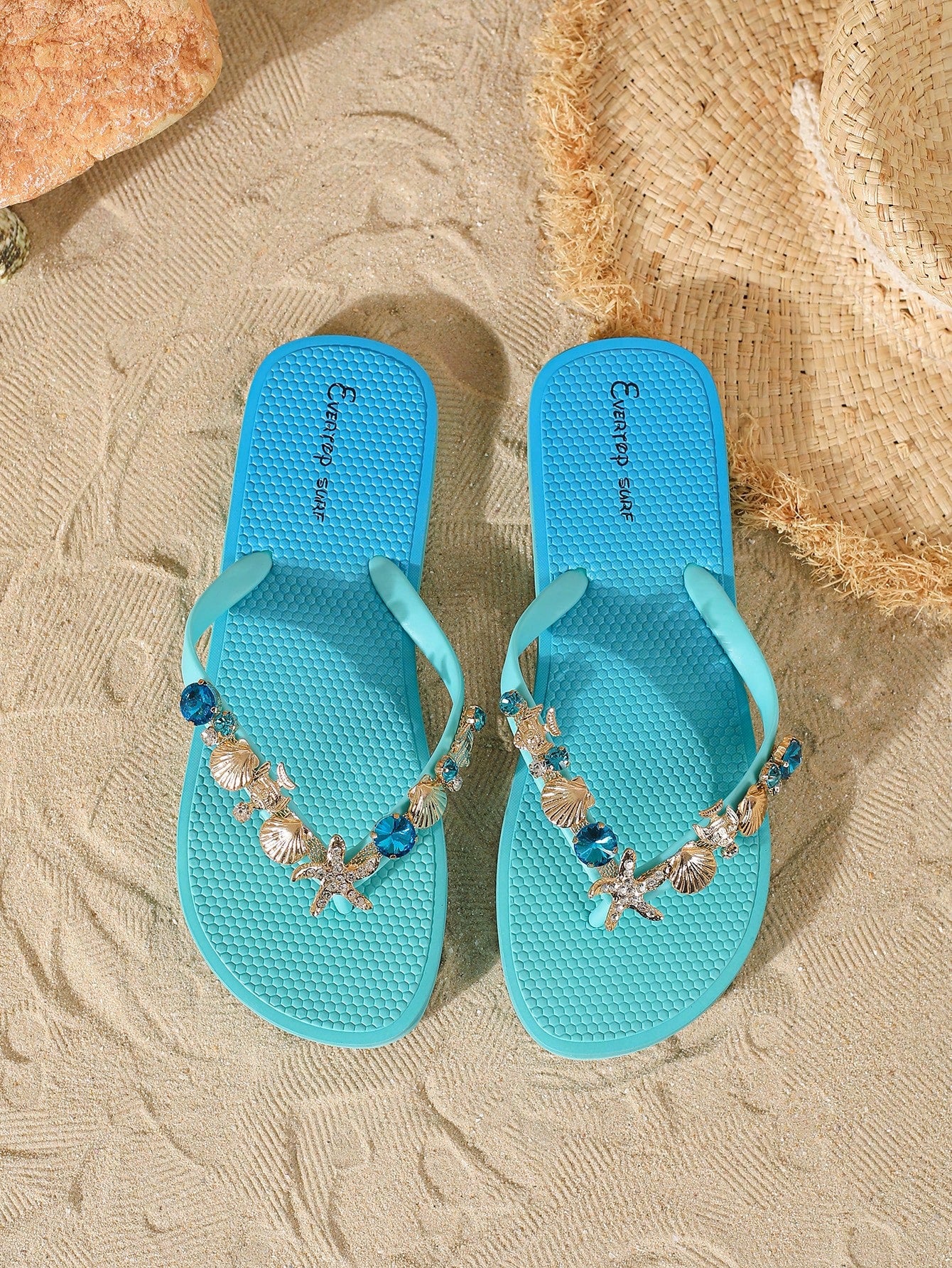 Women’s fashion flip flops with thong strap, beaded shell chain decoration, and removable decor chain detail, designed with a soft flat sole for beach and vacation use.