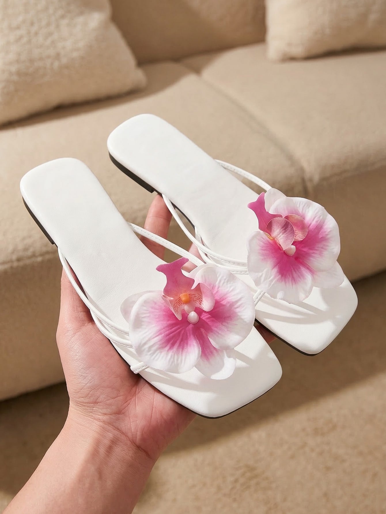 Women's flat woven slide sandals with open toe, featuring 3D flower and pearl appliques in an apricot and blue flower colorway, shown as casual vacation beach slippers.