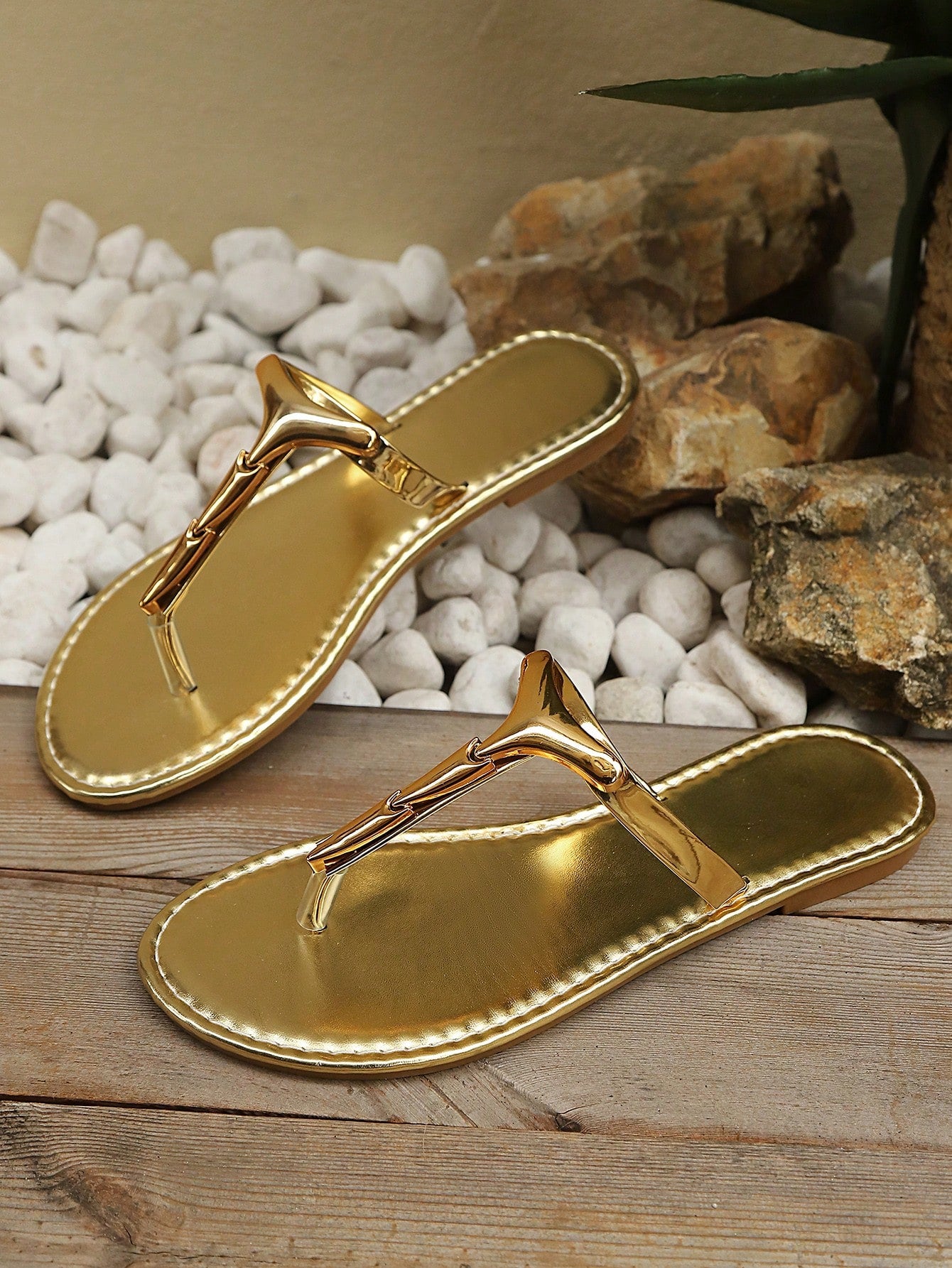 Women’s gold flat slide sandals with open toe post design and metal buckle detail, shown as fashionable outdoor summer footwear.