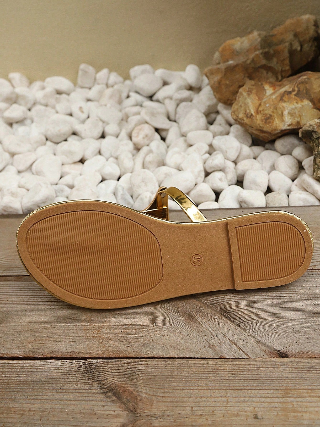 Women’s gold flat slide sandals with open toe post design and metal buckle detail, shown as fashionable outdoor summer footwear.