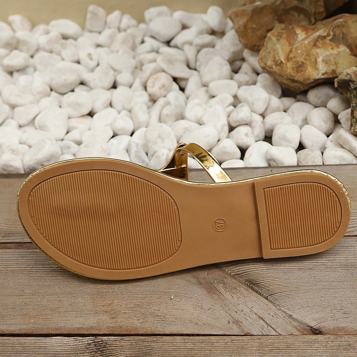 Women’s gold flat slide sandals with open toe post design and metal buckle detail, shown as fashionable outdoor summer footwear.
