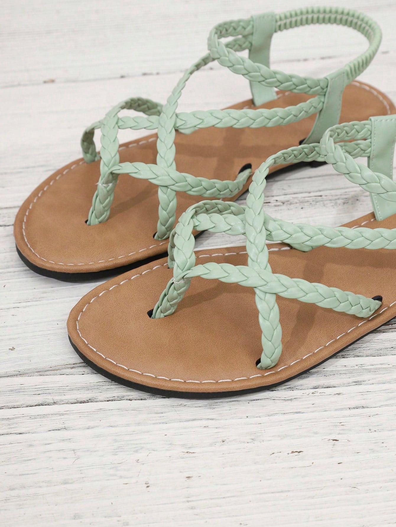 Women's woven criss-cross elastic flat sandals with braided strappy upper and toe post design