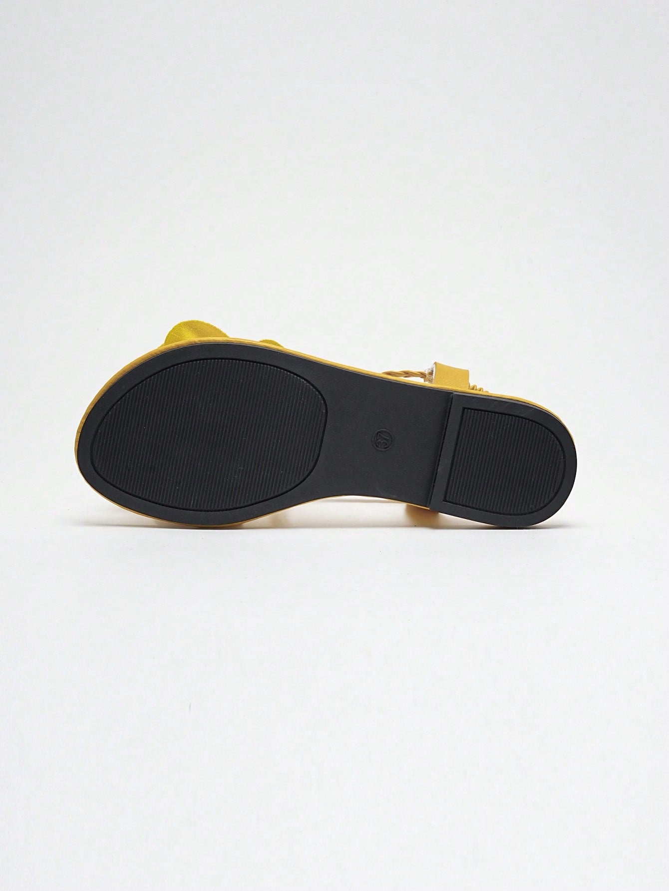 Women's open-toe flat slide sandals with crossed woven-look straps, floral appliqué detail, and buckle accent, shown in a casual beach style.