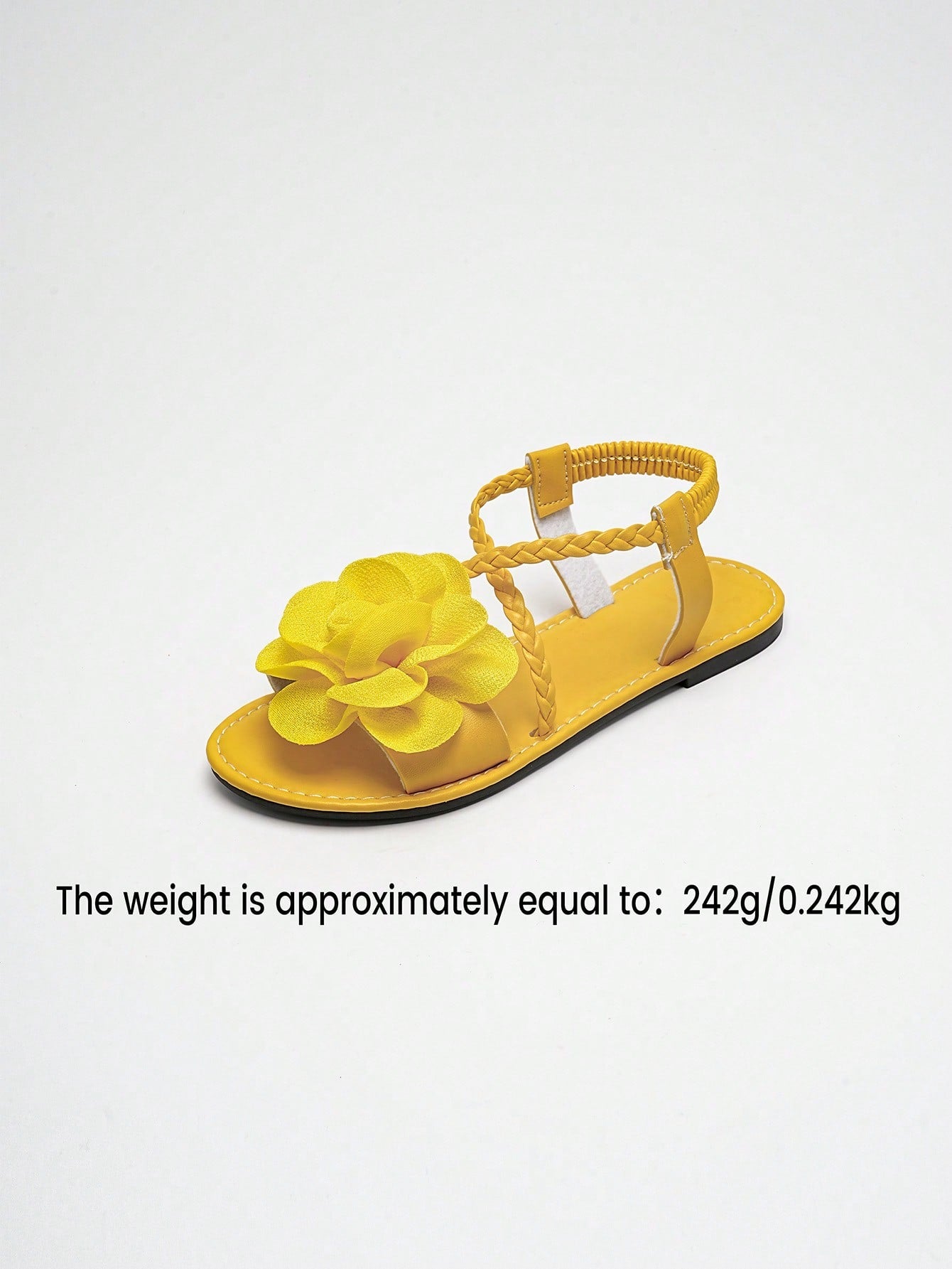 Women's open-toe flat slide sandals with crossed woven-look straps, floral appliqué detail, and buckle accent, shown in a casual beach style.