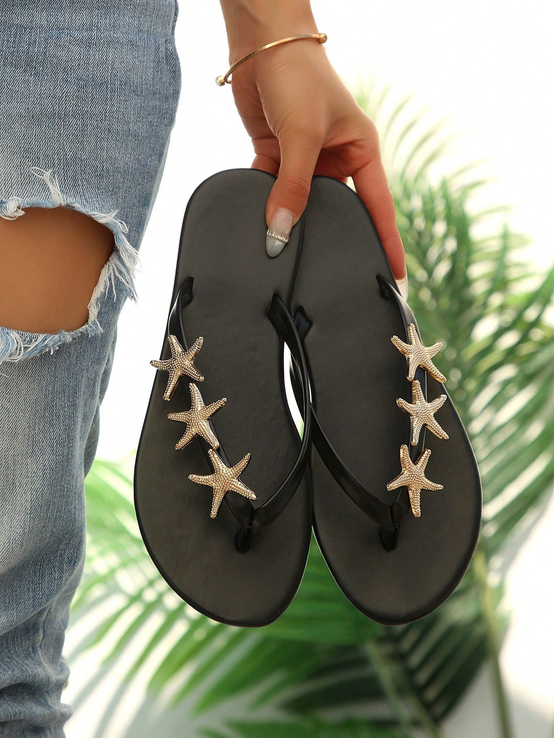 Women's black strappy flip flops with geometric pattern and star detail, flat heel, slip-on style, suitable for beach, indoor, and outdoor walking.