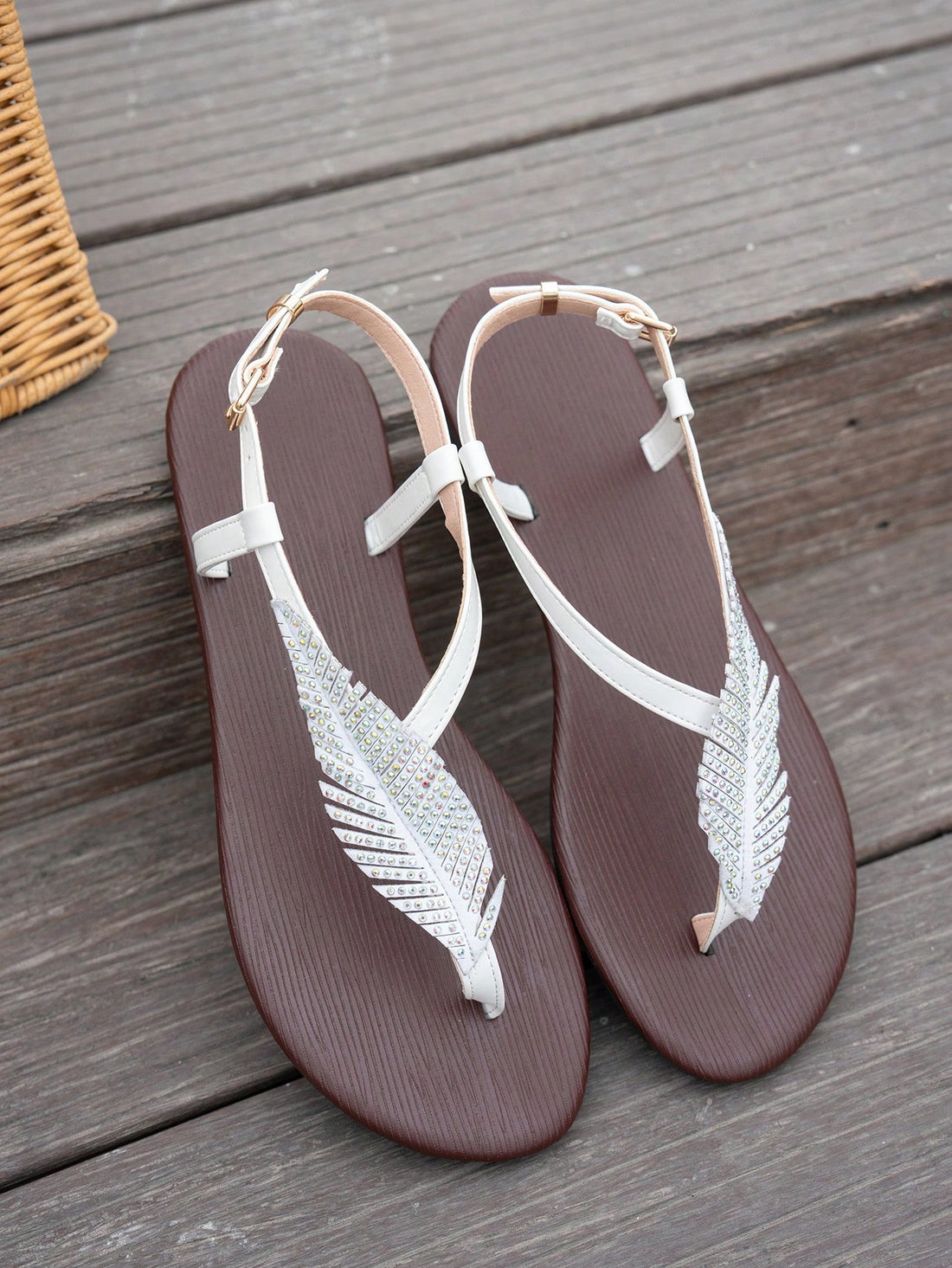 Women’s white flat thong sandals with toe-post design, leaf rhinestone embellishment, and buckle detail, suitable for beach, walking, and home wear.