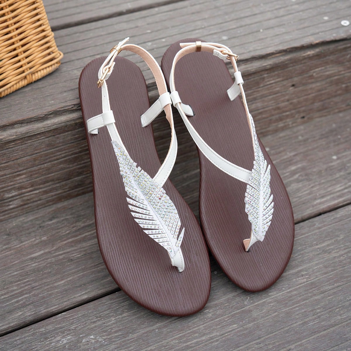 Women’s white flat thong sandals with toe-post design, leaf rhinestone embellishment, and buckle detail, suitable for beach, walking, and home wear.