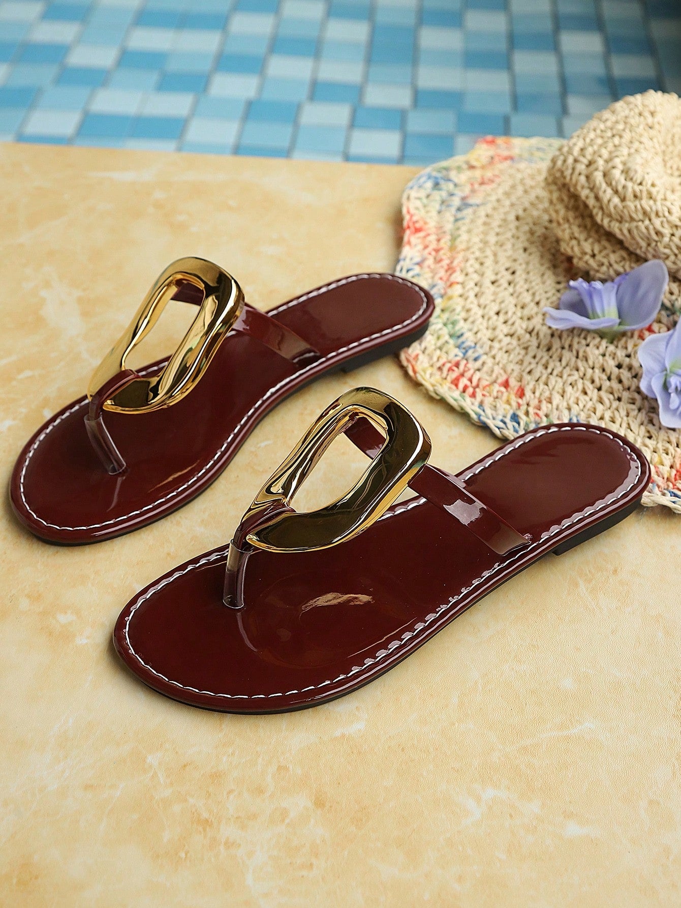 Women’s gold flat slide sandals with open toe post design and metal buckle detail, shown as fashionable outdoor summer footwear.