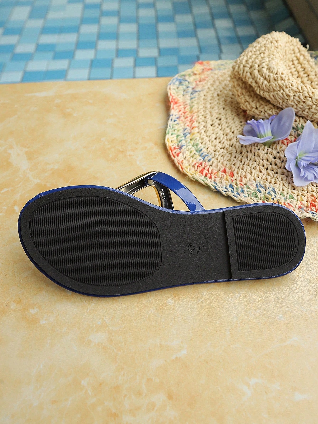 Women’s gold flat slide sandals with open toe post design and metal buckle detail, shown as fashionable outdoor summer footwear.