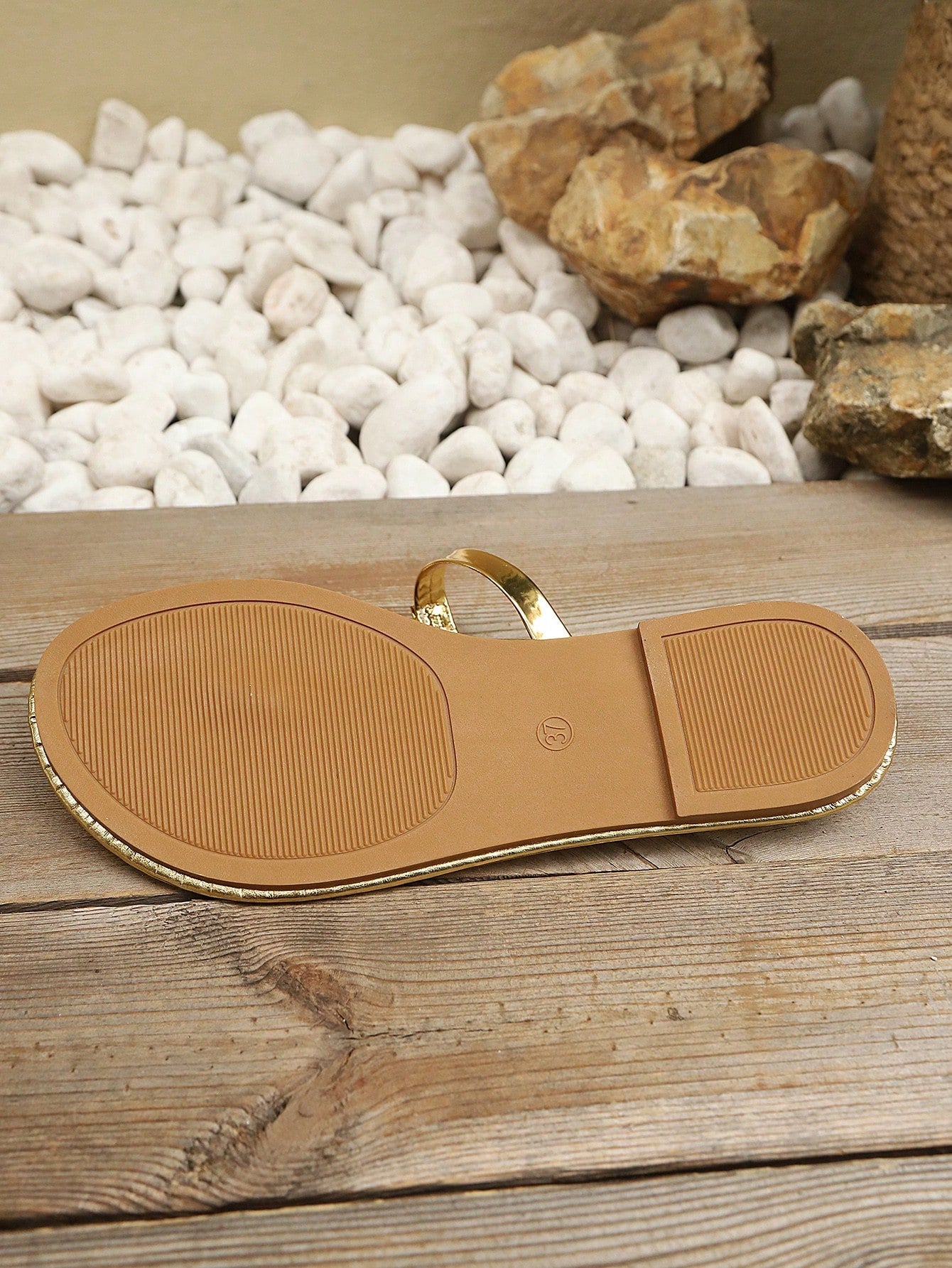 Women’s gold flat slide sandals with open toe post design and metal buckle detail, shown as fashionable outdoor summer footwear.
