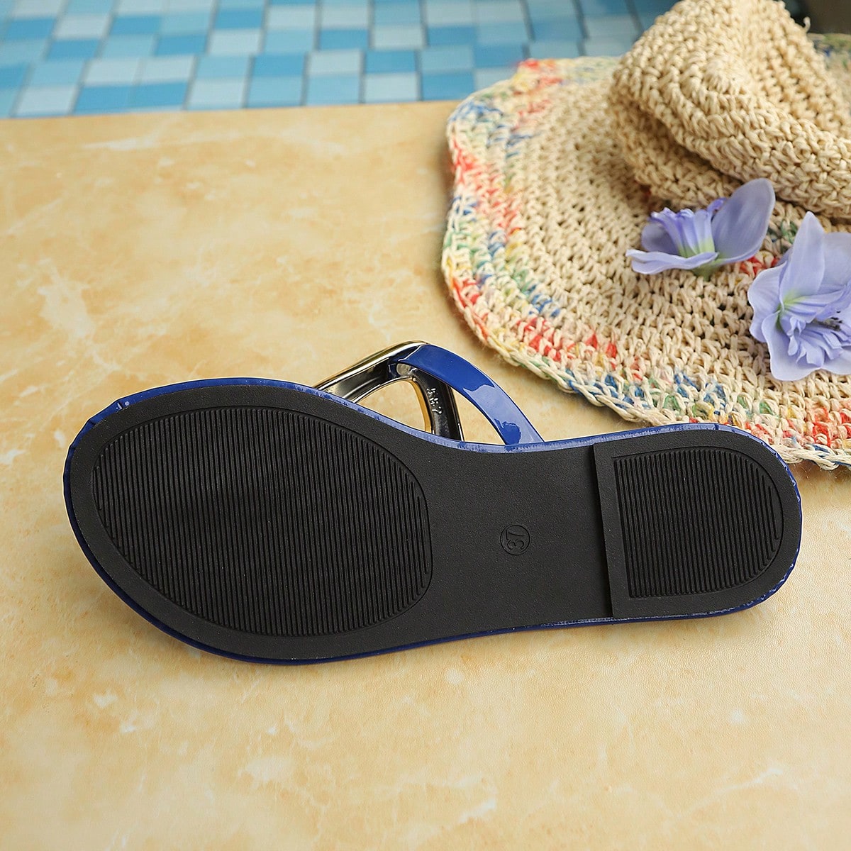 Women’s gold flat slide sandals with open toe post design and metal buckle detail, shown as fashionable outdoor summer footwear.
