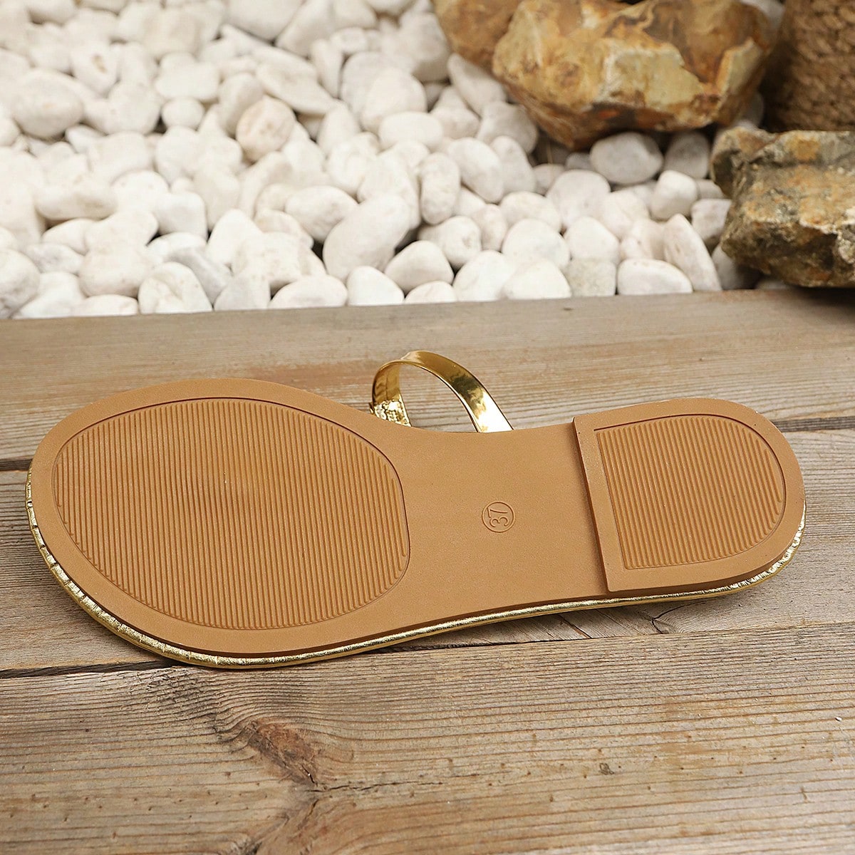 Women’s gold flat slide sandals with open toe post design and metal buckle detail, shown as fashionable outdoor summer footwear.