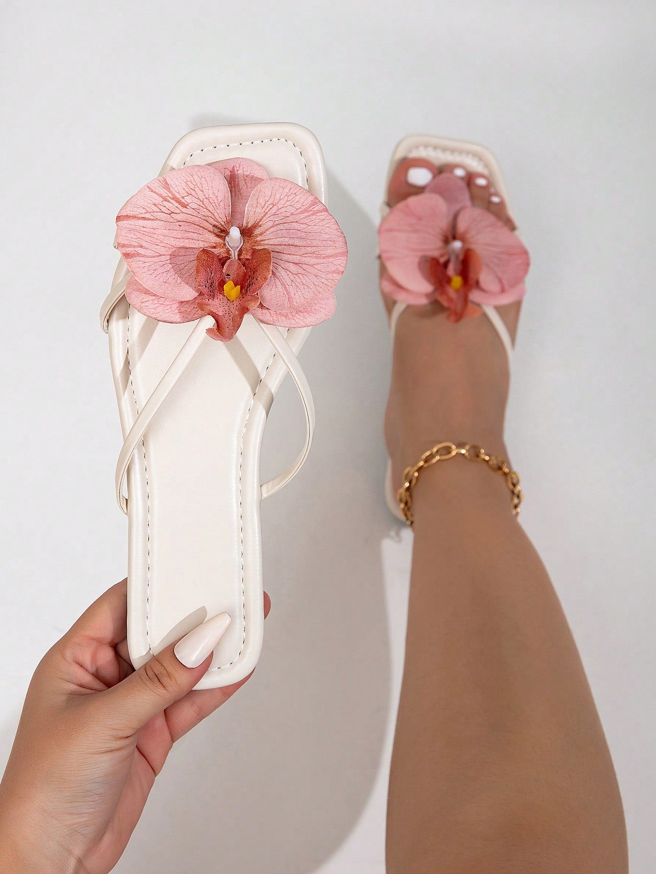 Wide fit women's beige flat thong sandals with butterfly orchid appliqué decor and open toe, suitable for beach, vacation, home, and casual everyday wear.