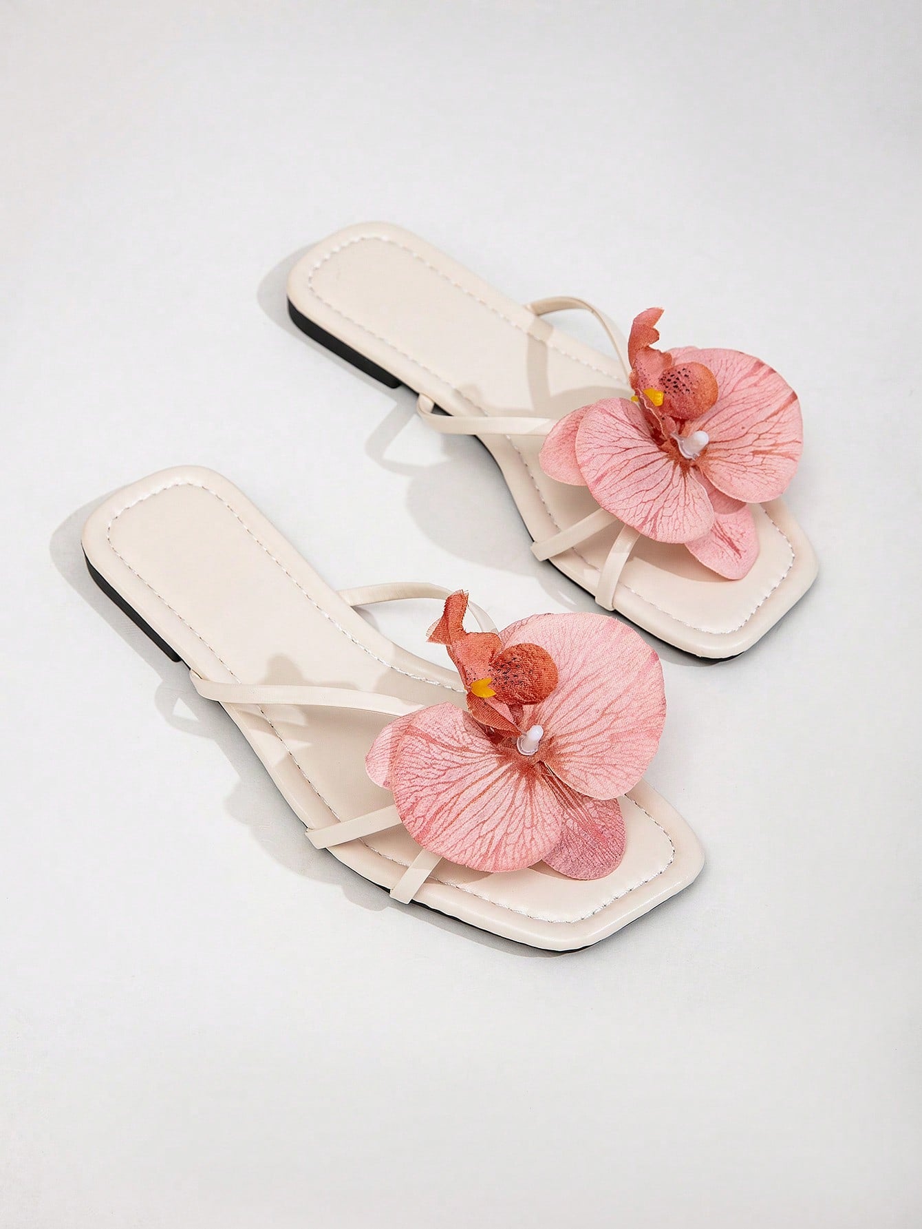 Wide fit women's beige flat thong sandals with butterfly orchid appliqué decor and open toe, suitable for beach, vacation, home, and casual everyday wear.