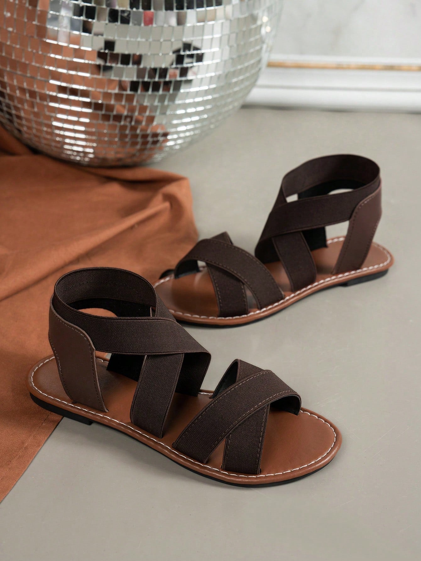 Women's wide fit flat slip-on sandals with criss-cross straps and open toe, designed for casual outdoor and beach wear.