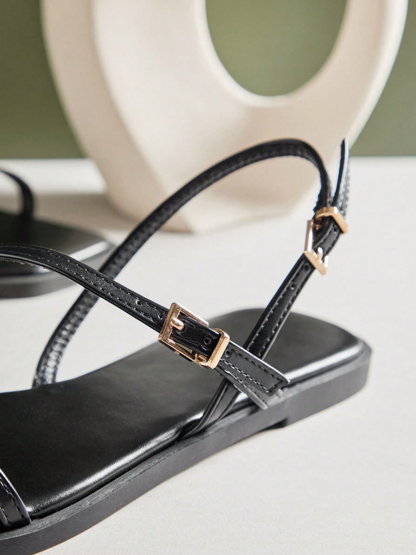Women's flat open-toe sandals featuring a buckle detail and PU leather construction with a flat sole.