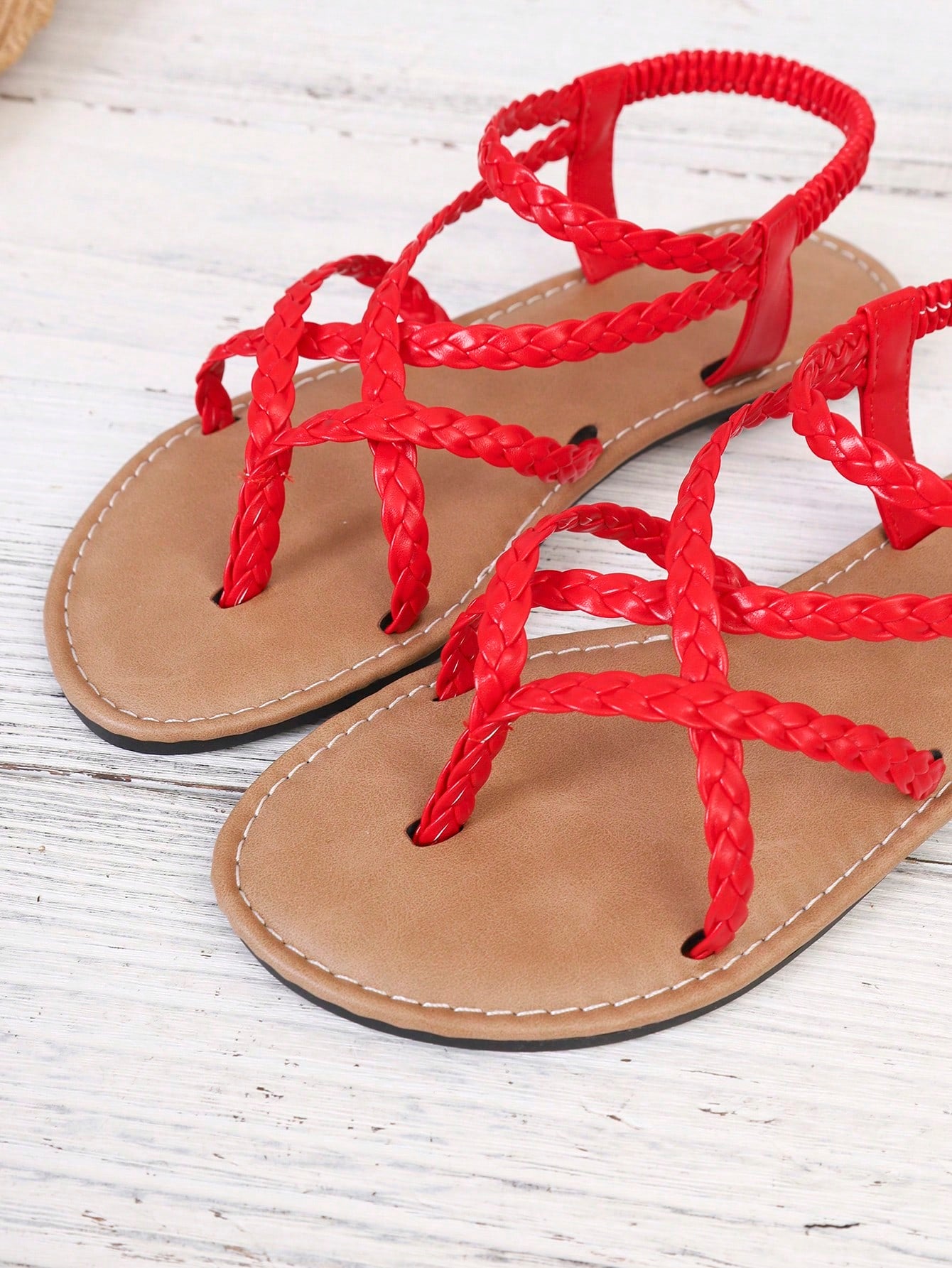 Women's woven criss-cross elastic flat sandals with braided strappy upper and toe post design