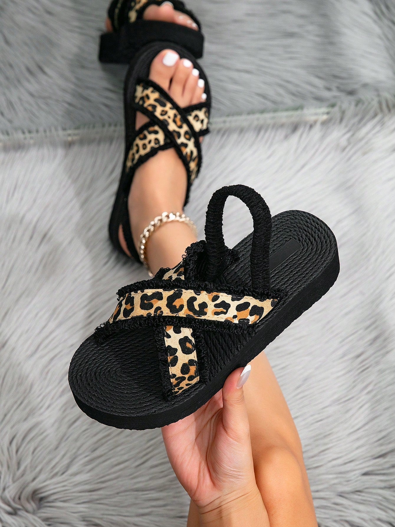 Women's open toe slip-on wedge sandals with criss cross straps and folk-custom styling, featuring raw hem, fringe, tassel, braid, and tape details.