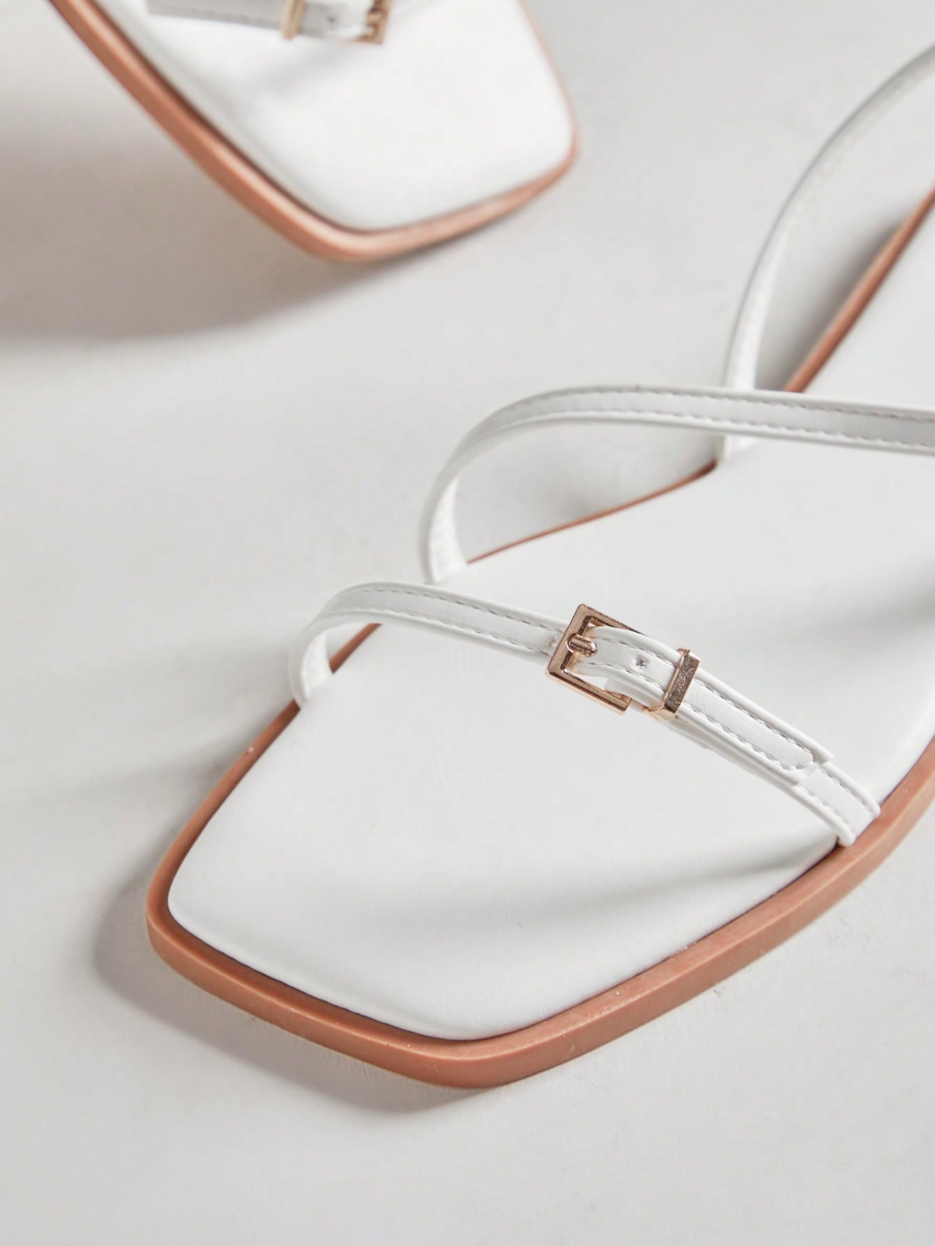 Women's flat open-toe sandals featuring a buckle detail and PU leather construction with a flat sole.