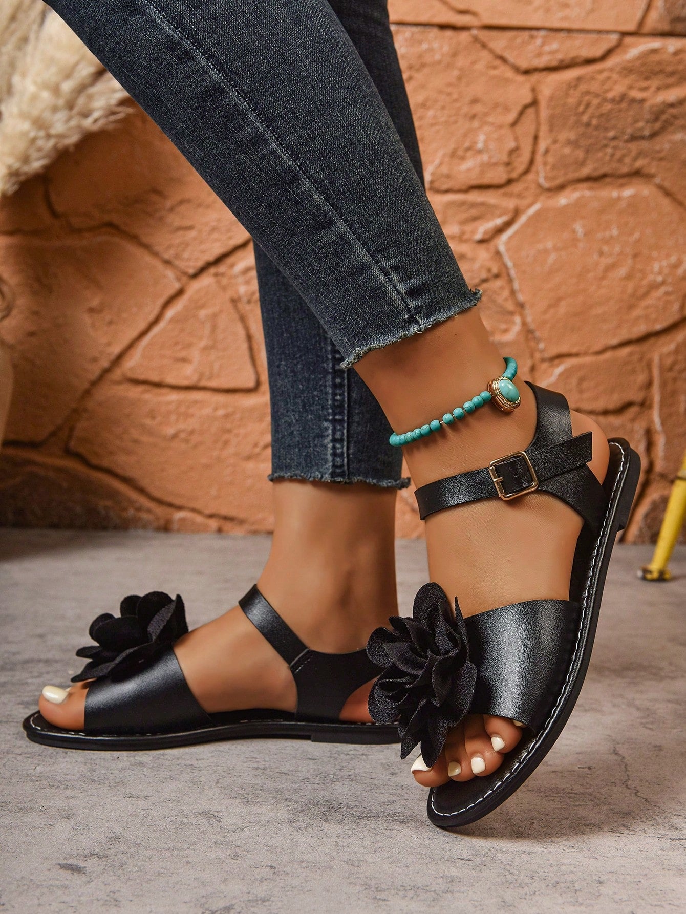 Women's wide width flat thong sandals in brown with toe post, buckle detail, and elastic strap, designed for comfortable beach and casual summer wear.