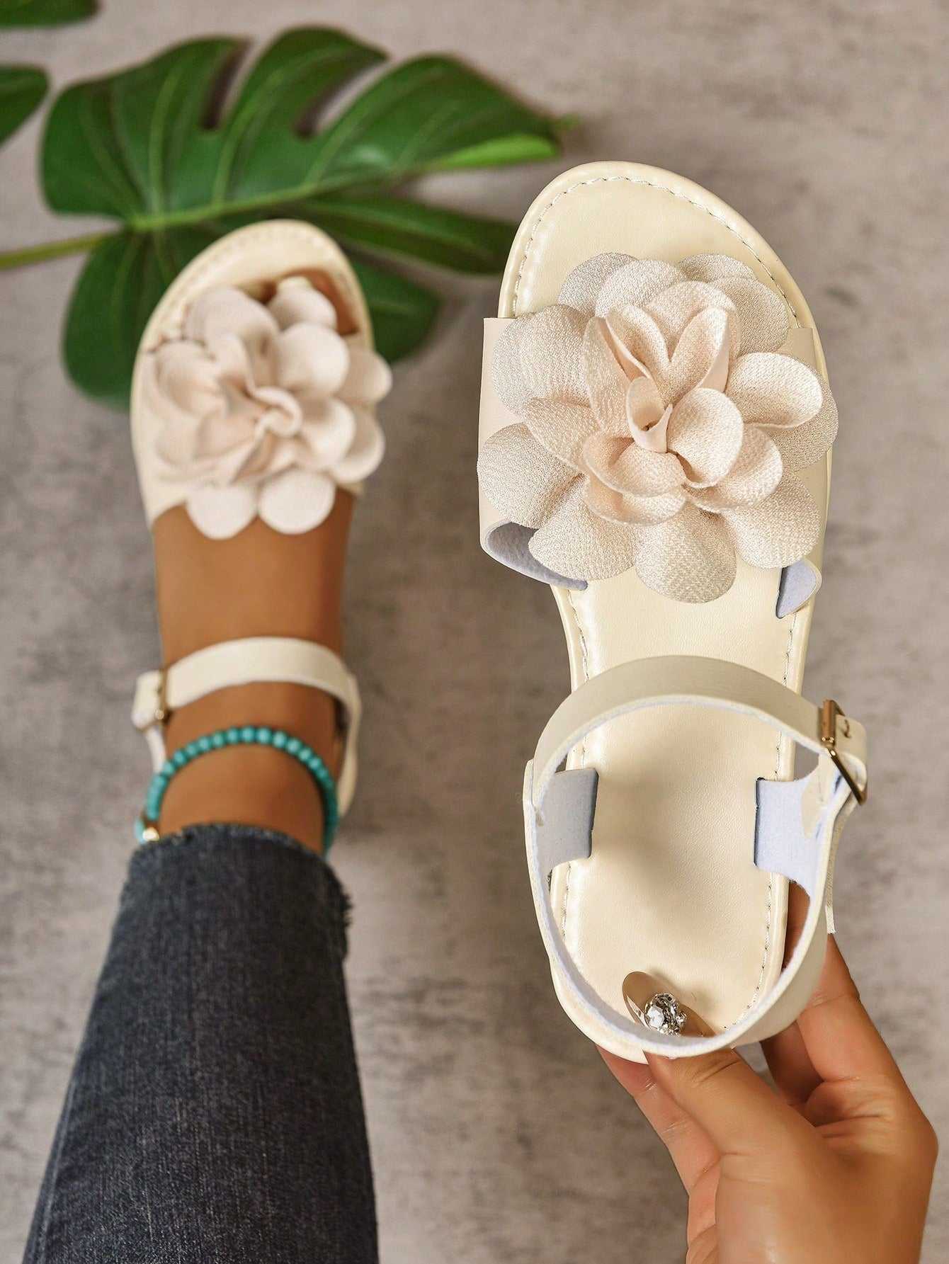 Women's wide width flat thong sandals in brown with toe post, buckle detail, and elastic strap, designed for comfortable beach and casual summer wear.