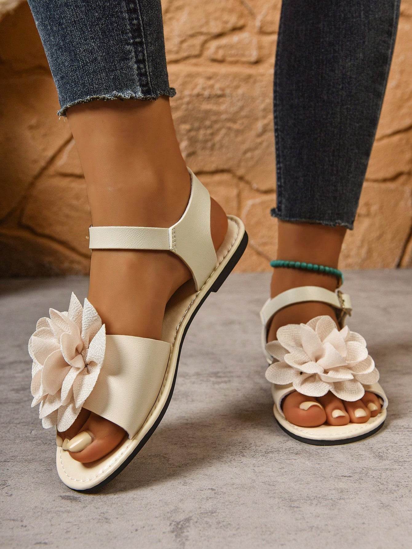 Women's wide width flat thong sandals in brown with toe post, buckle detail, and elastic strap, designed for comfortable beach and casual summer wear.