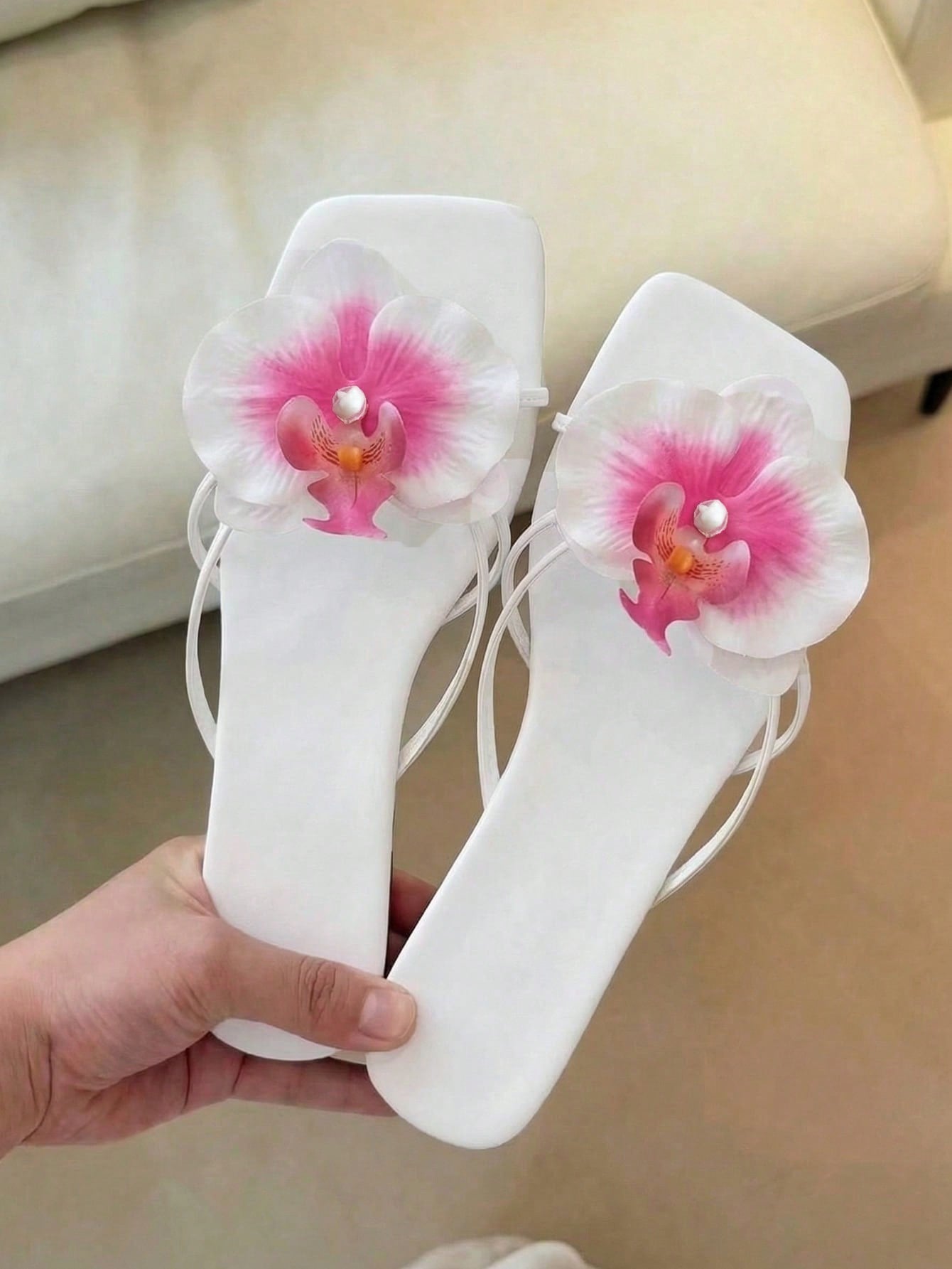 Women's flat woven slide sandals with open toe, featuring 3D flower and pearl appliques in an apricot and blue flower colorway, shown as casual vacation beach slippers.