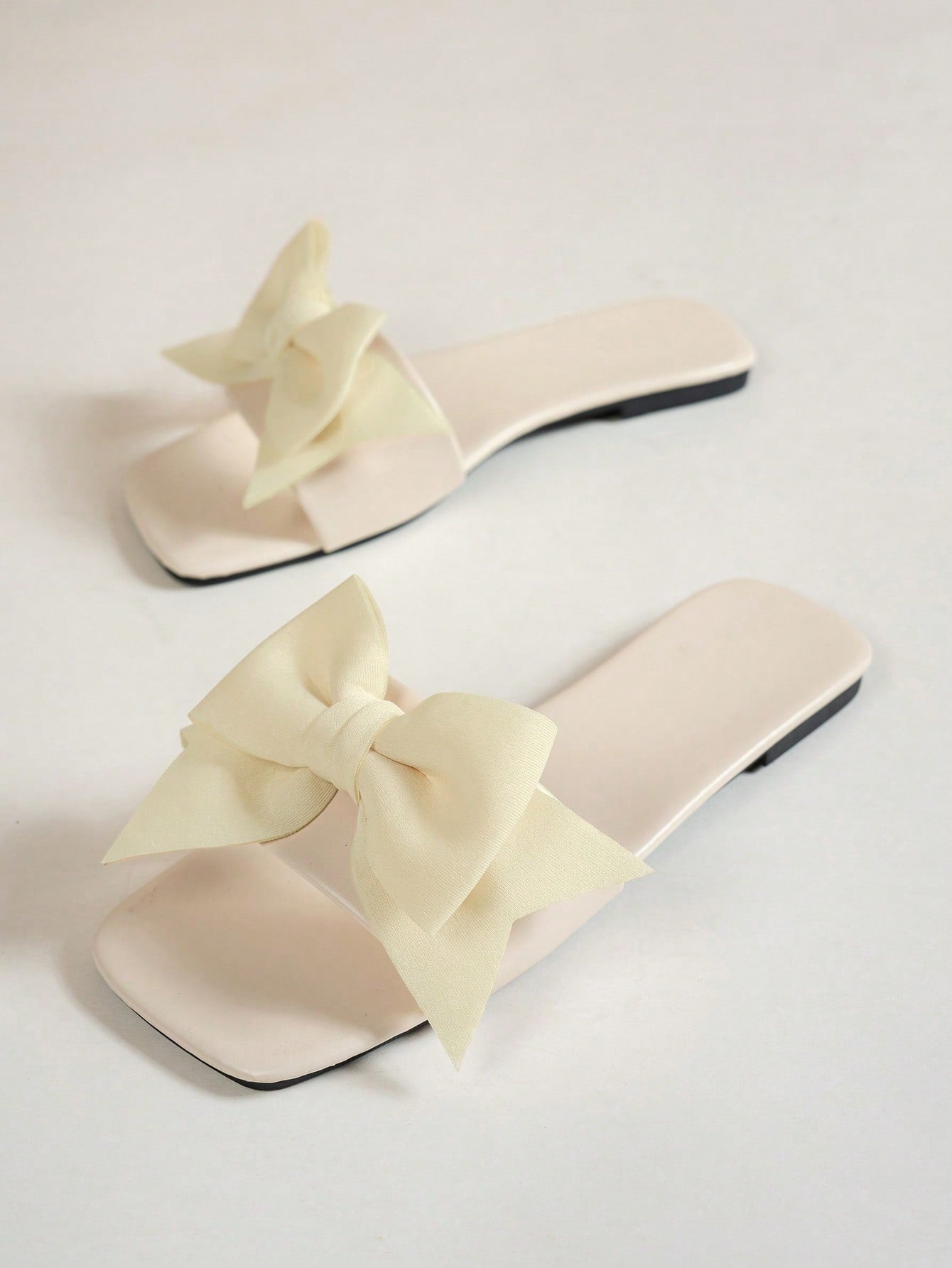 Women's flat slide sandals with a square open toe, geometric detail, and PU leather construction with rubber outsole.