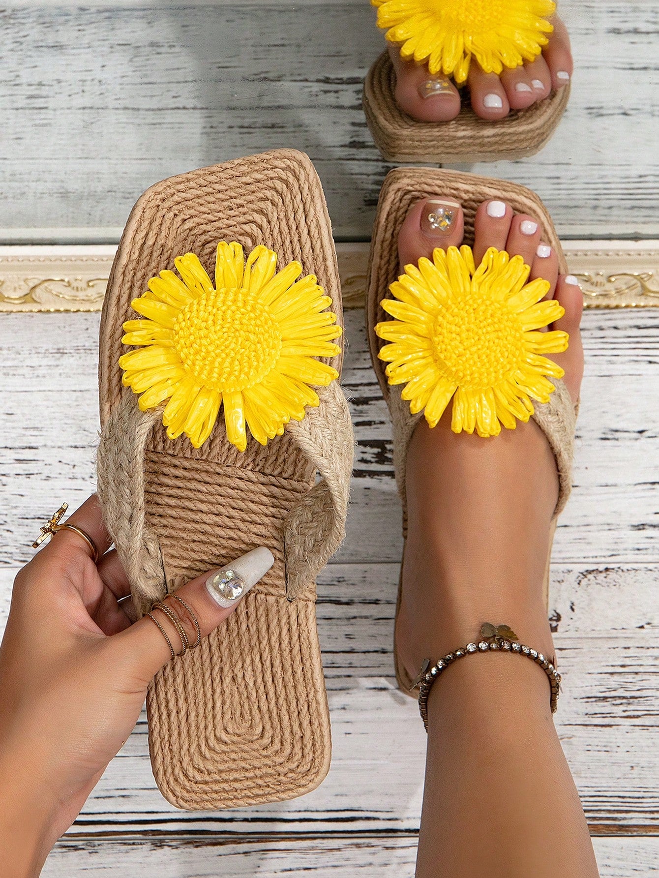 Women’s flat linen flip-flops with flower appliqué decor and sole, beach slipper style.