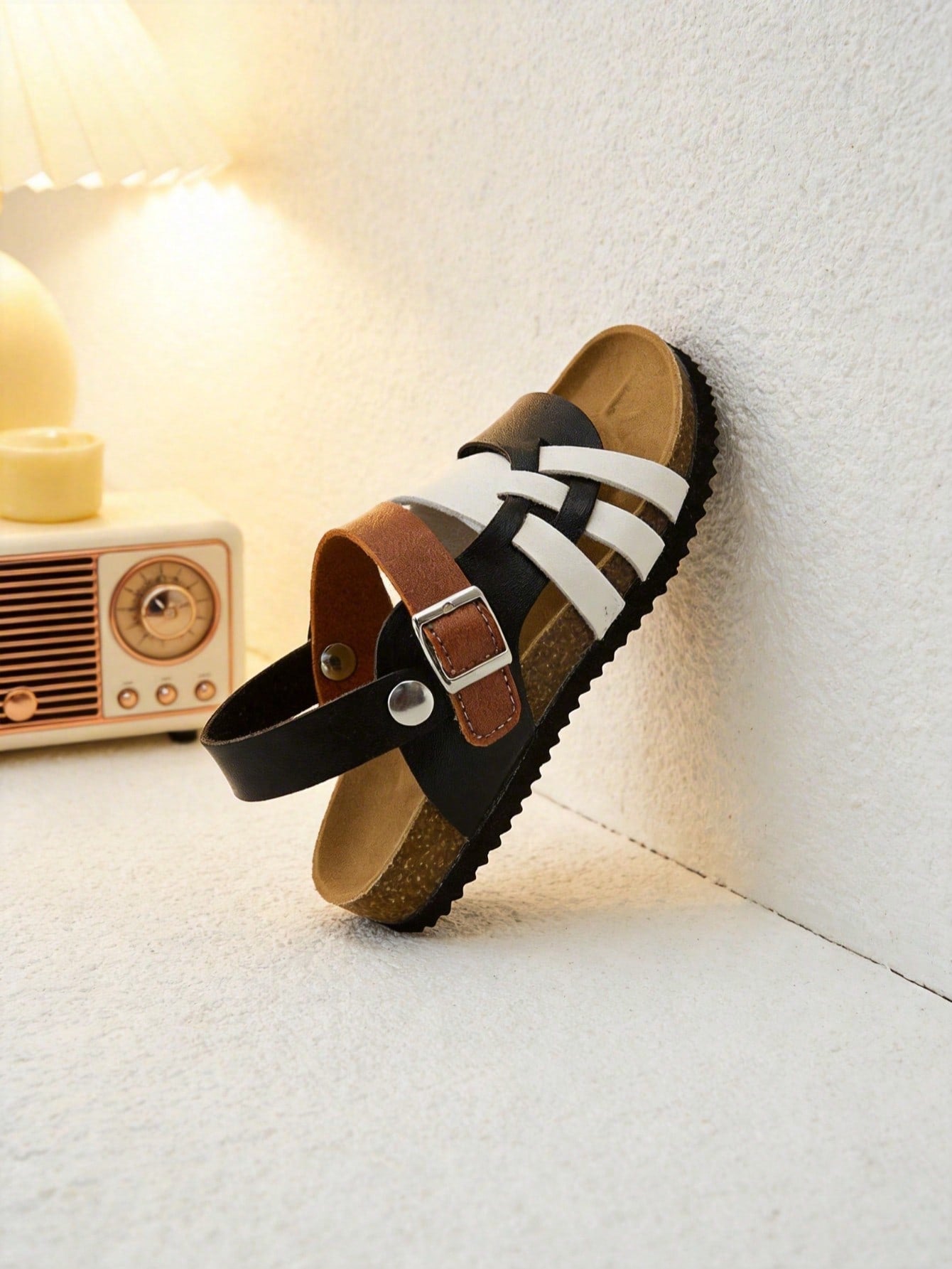 Pair of girls' pink open-toe flat sandals with ankle straps, buckle details, and a non-slip black rubber outsole.