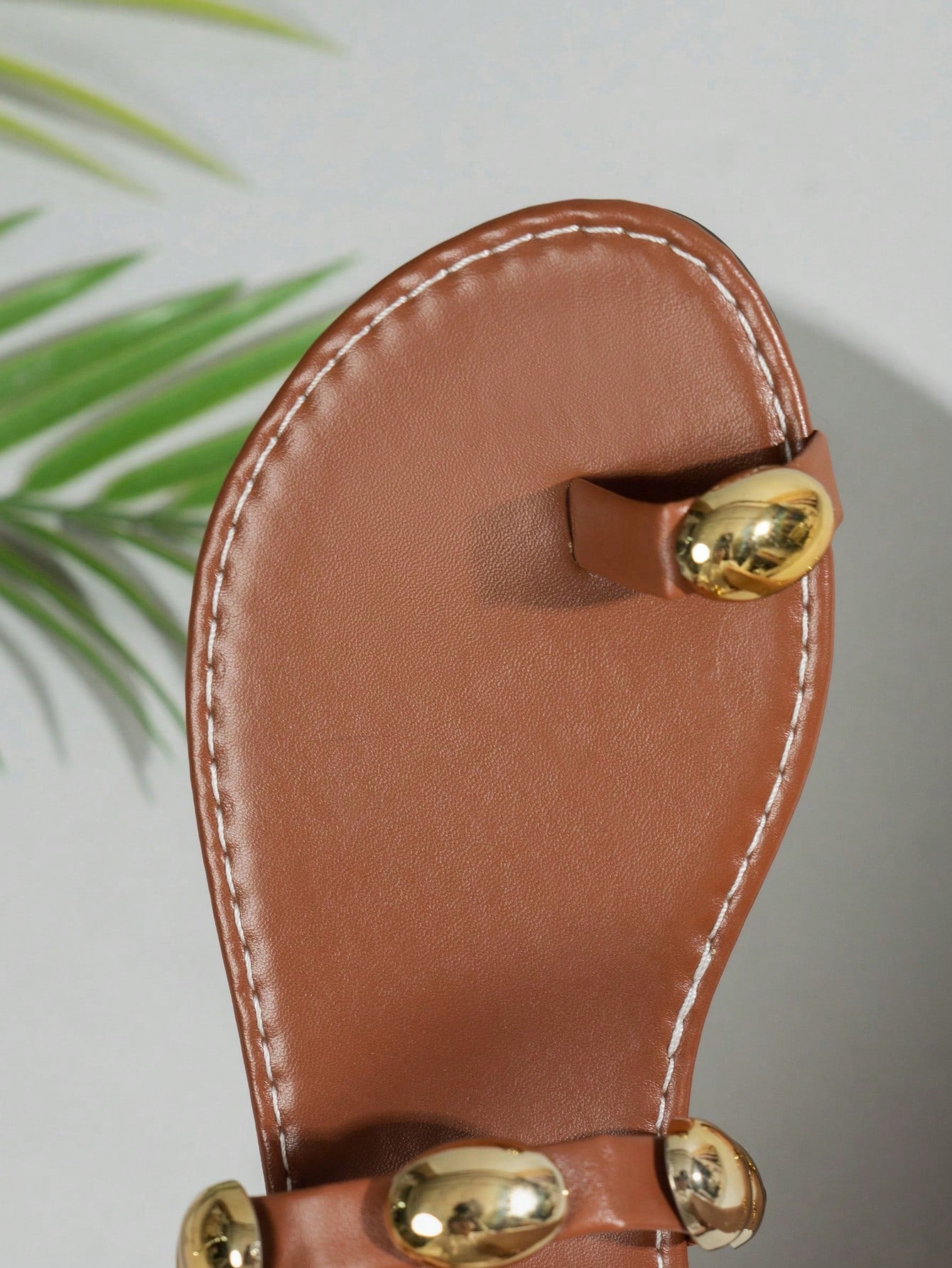 Women's brown flat toe-post sandals with beaded bohemian styling, plant pattern details, metal accents, and a PU leather upper, shown as a classic beach sandal.