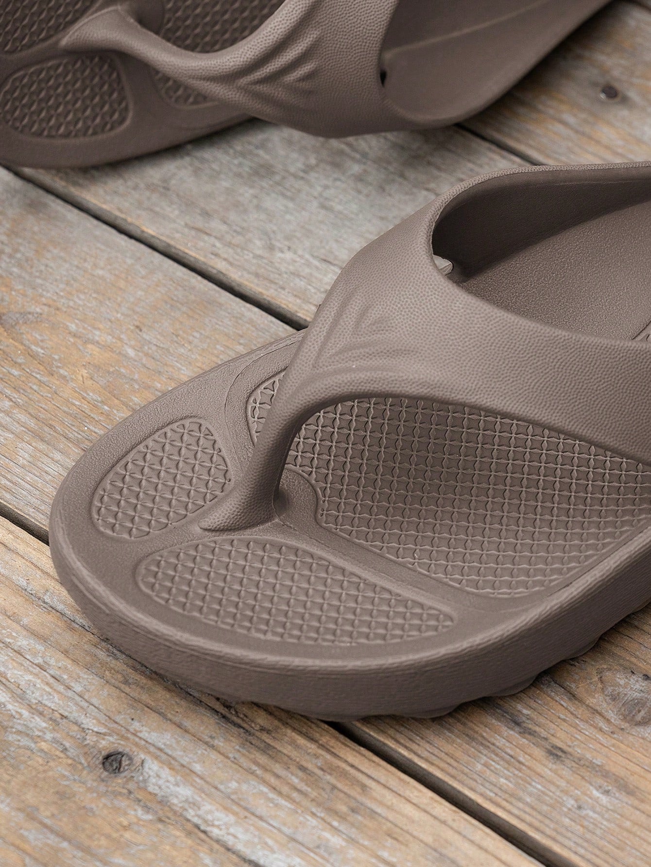 Women's solid color flip flops with open-toe design, flat sole, and cut-out details, suitable for casual indoor or outdoor wear at the beach or pool.