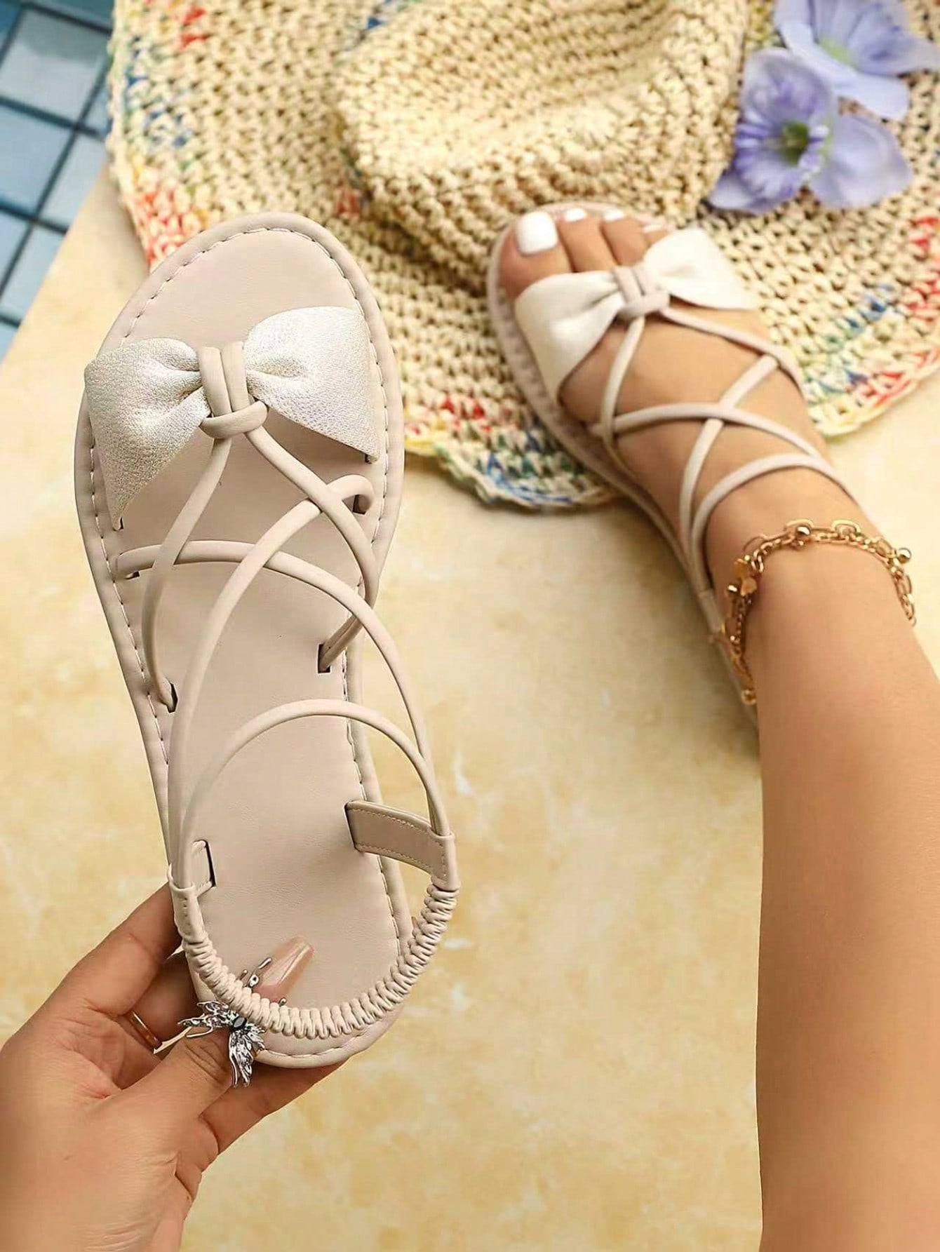 Women's flat gladiator sandals with thin criss-cross straps, bow detail, and elastic back strap, shown in Black, White, and Beige color options.