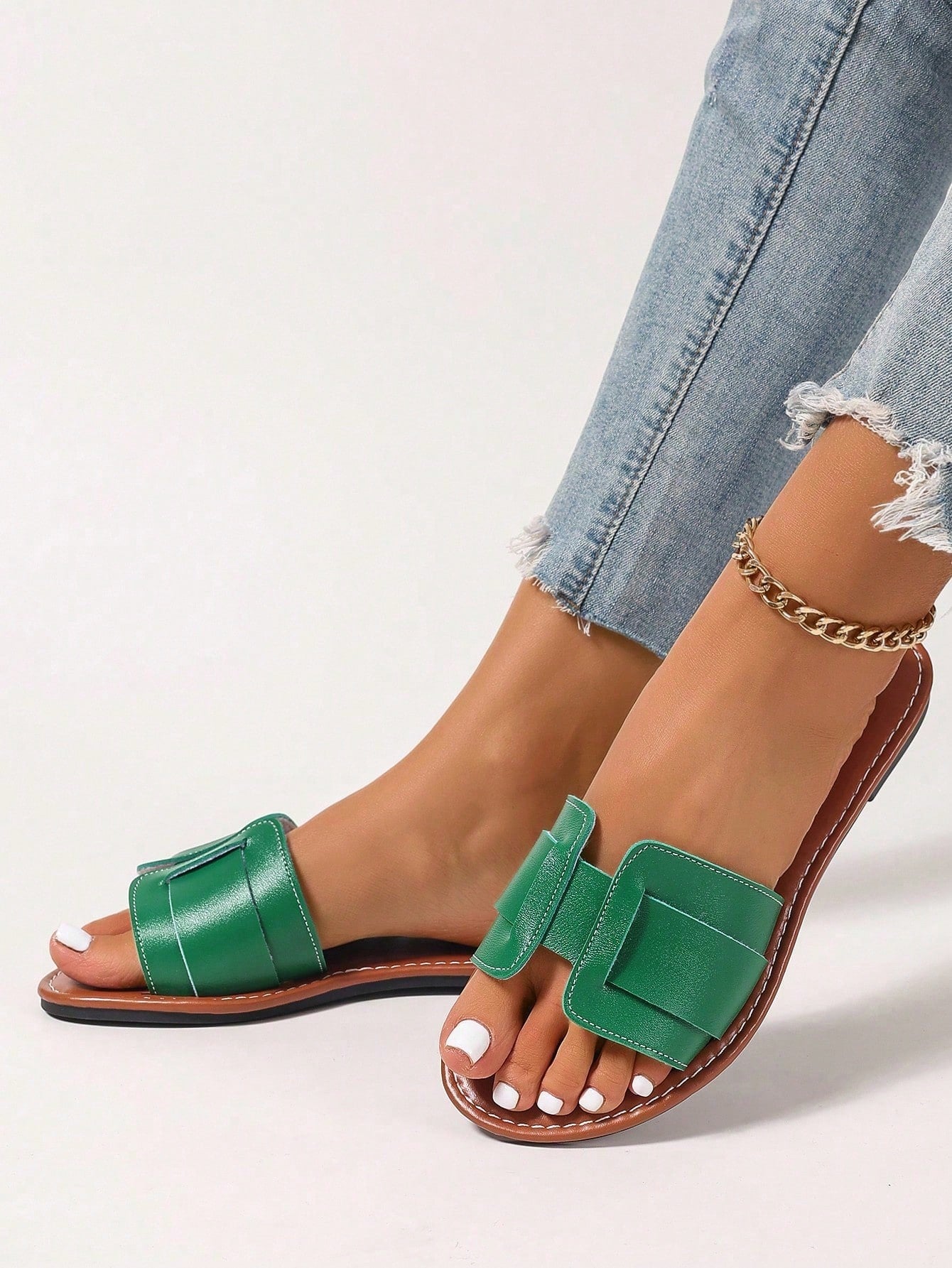 Women’s flat open-toe slide sandals with braided strap detail, embossed texture, and rhinestone decoration, designed as casual slip-on footwear for beach and everyday outdoor wear.