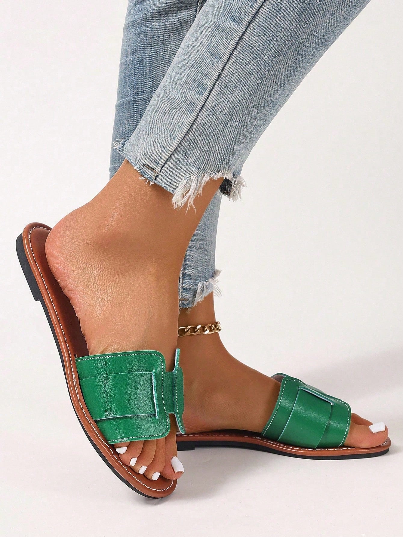 Women’s flat open-toe slide sandals with braided strap detail, embossed texture, and rhinestone decoration, designed as casual slip-on footwear for beach and everyday outdoor wear.