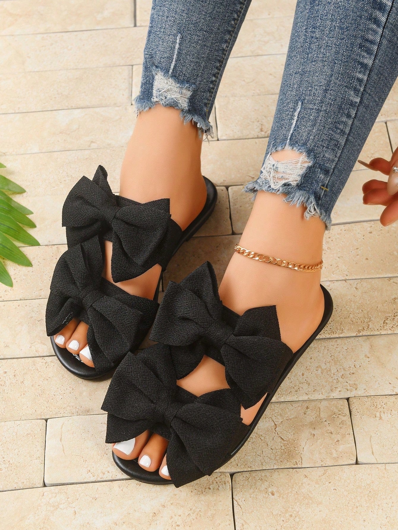 Women's wide width flat slip-on sandals with bow decor and open toe in a classic casual style