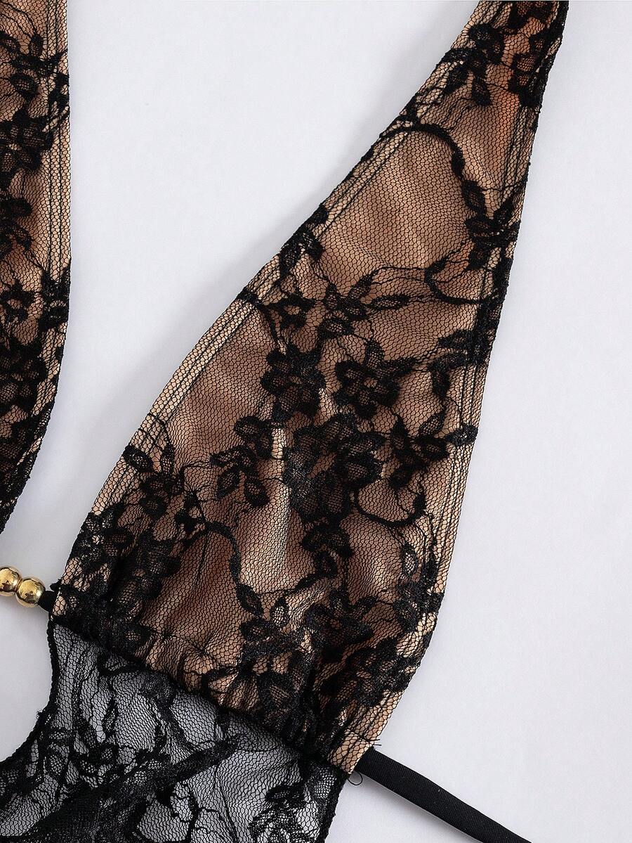 Women's black 3-piece bikini set with halter triangle top, backless design, ruched thong bottoms, and matching lace skirt for beach or vacation wear.