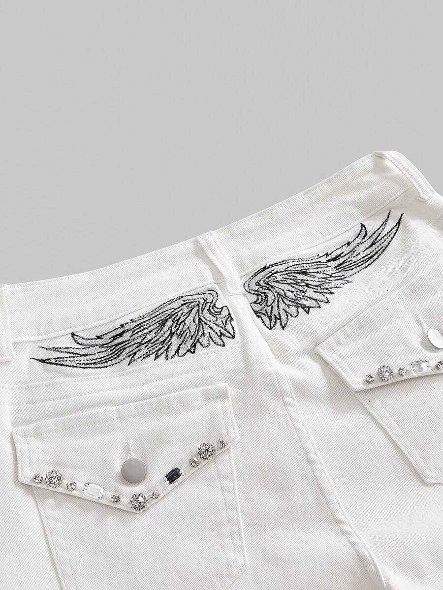 Blue ultra low waist mini shorts with ripped details, zipper fly, button closure, back wing embroidery, and rhinestone decor in a Y2K grunge punk style.