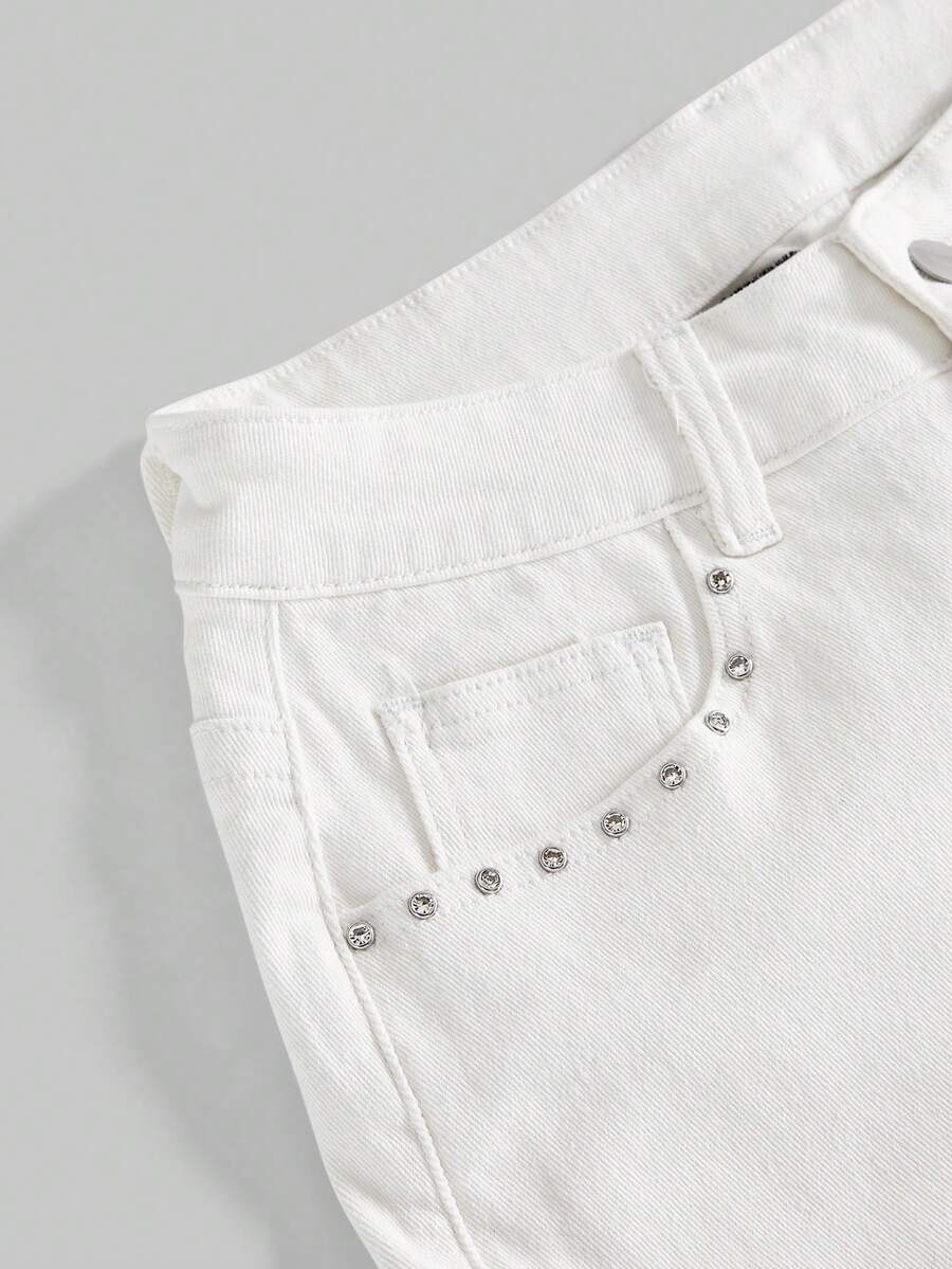 Blue ultra low waist mini shorts with ripped details, zipper fly, button closure, back wing embroidery, and rhinestone decor in a Y2K grunge punk style.