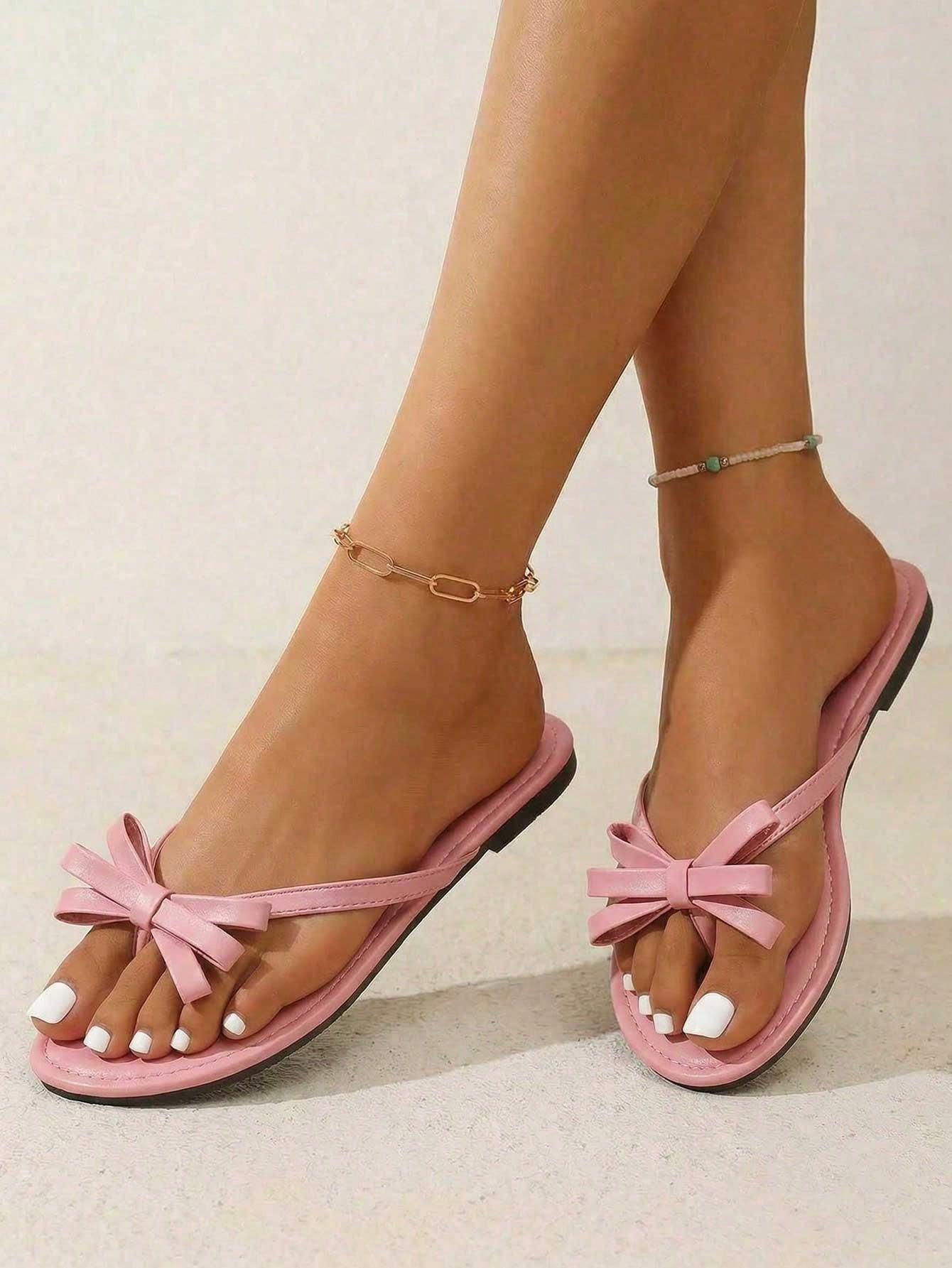 Women's flat slip-on slide sandals with textured PU leather look, bow detail on the upper, and toe-post design for casual vacation and beach wear.
