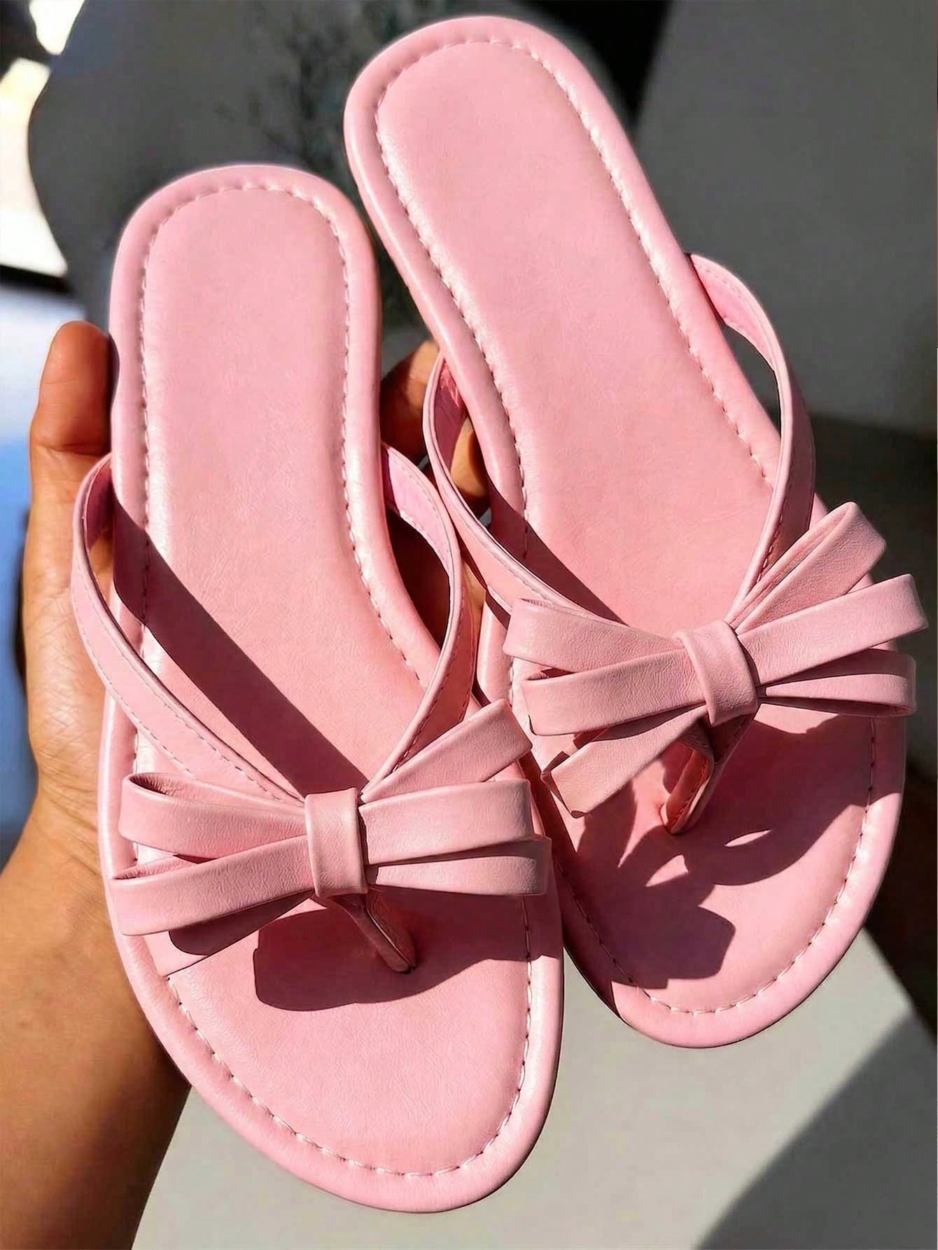 Women's flat slip-on slide sandals with textured PU leather look, bow detail on the upper, and toe-post design for casual vacation and beach wear.