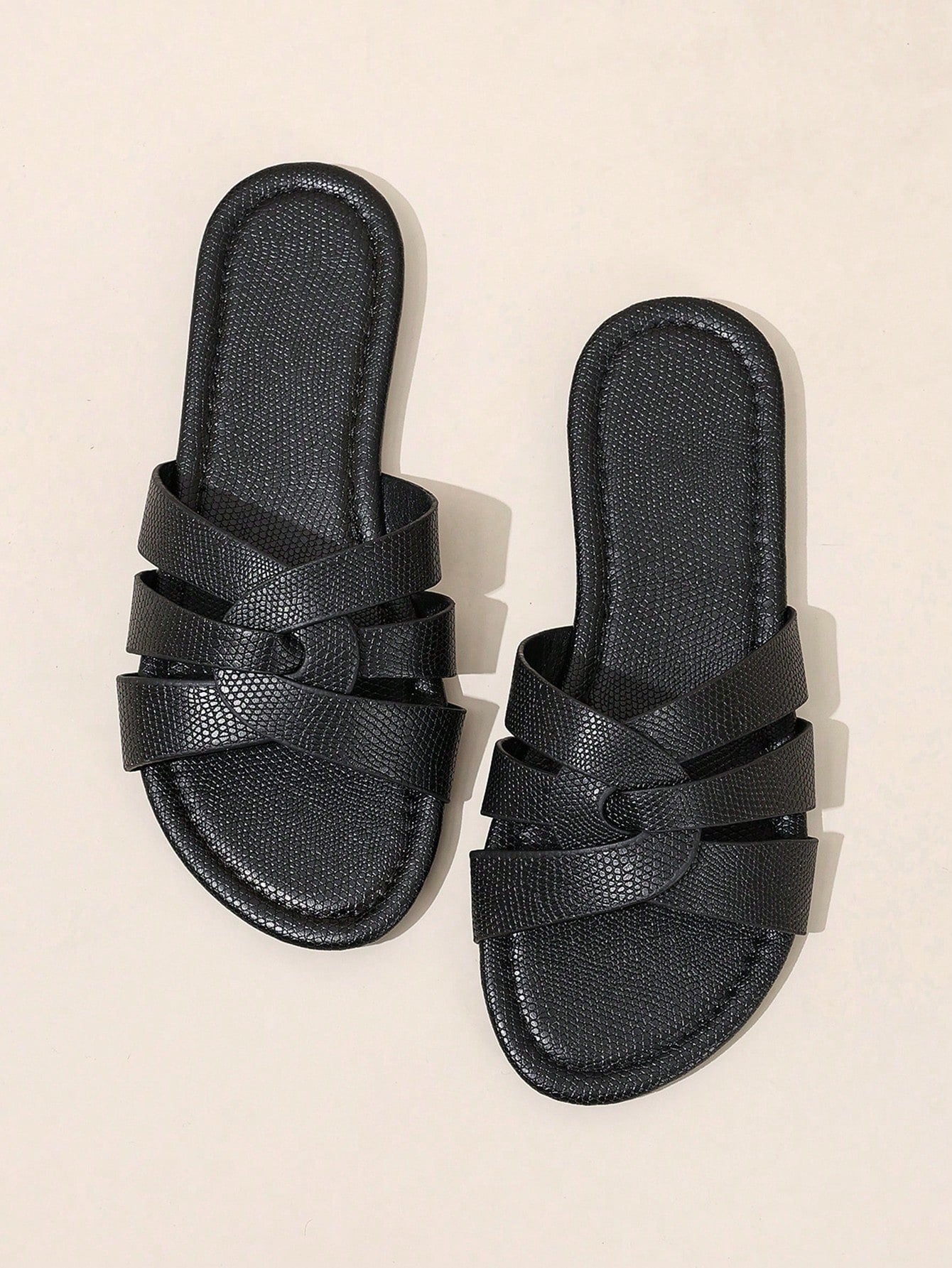 Pair of women’s open-toe flat slide sandals with an H-shaped strap, braided and embossed details, and a minimalist slip-on design suitable for casual outdoor wear.
