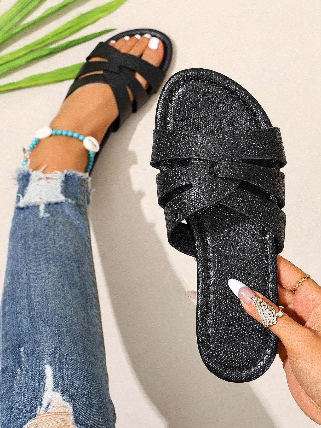 Pair of women’s open-toe flat slide sandals with an H-shaped strap, braided and embossed details, and a minimalist slip-on design suitable for casual outdoor wear.