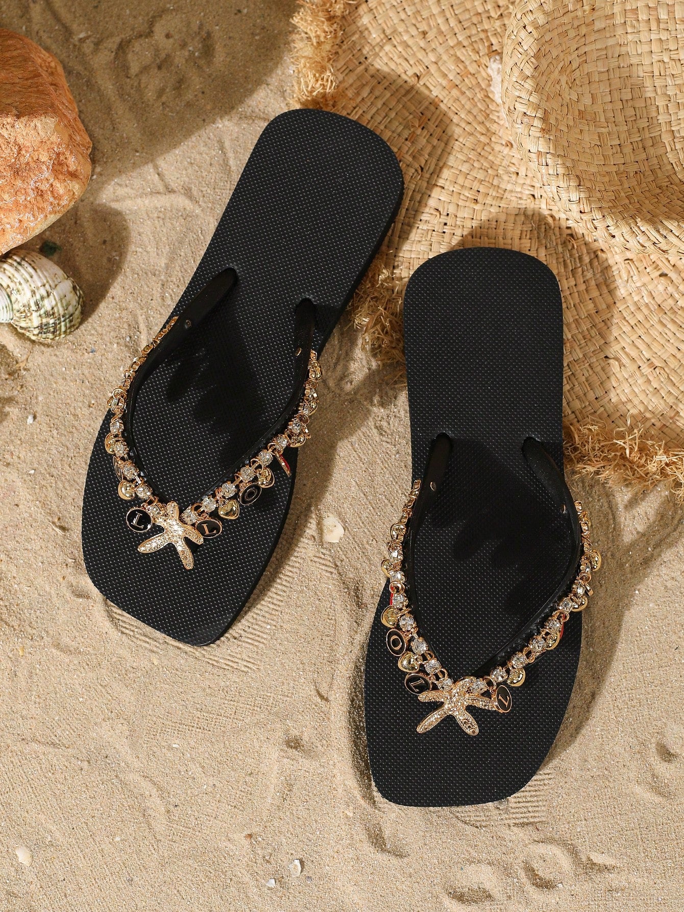 Women’s black flip flops with beaded and rhinestone LOVE letter decoration and a removable chain detail, flat soft sole vacation-style sandals.
