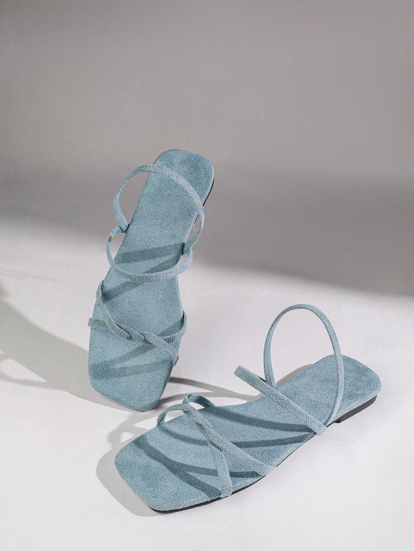 Women's flat sandals with a square open toe, crisscross front straps, and an elastic ankle strap, suitable for casual summer outdoor and beach vacation wear.