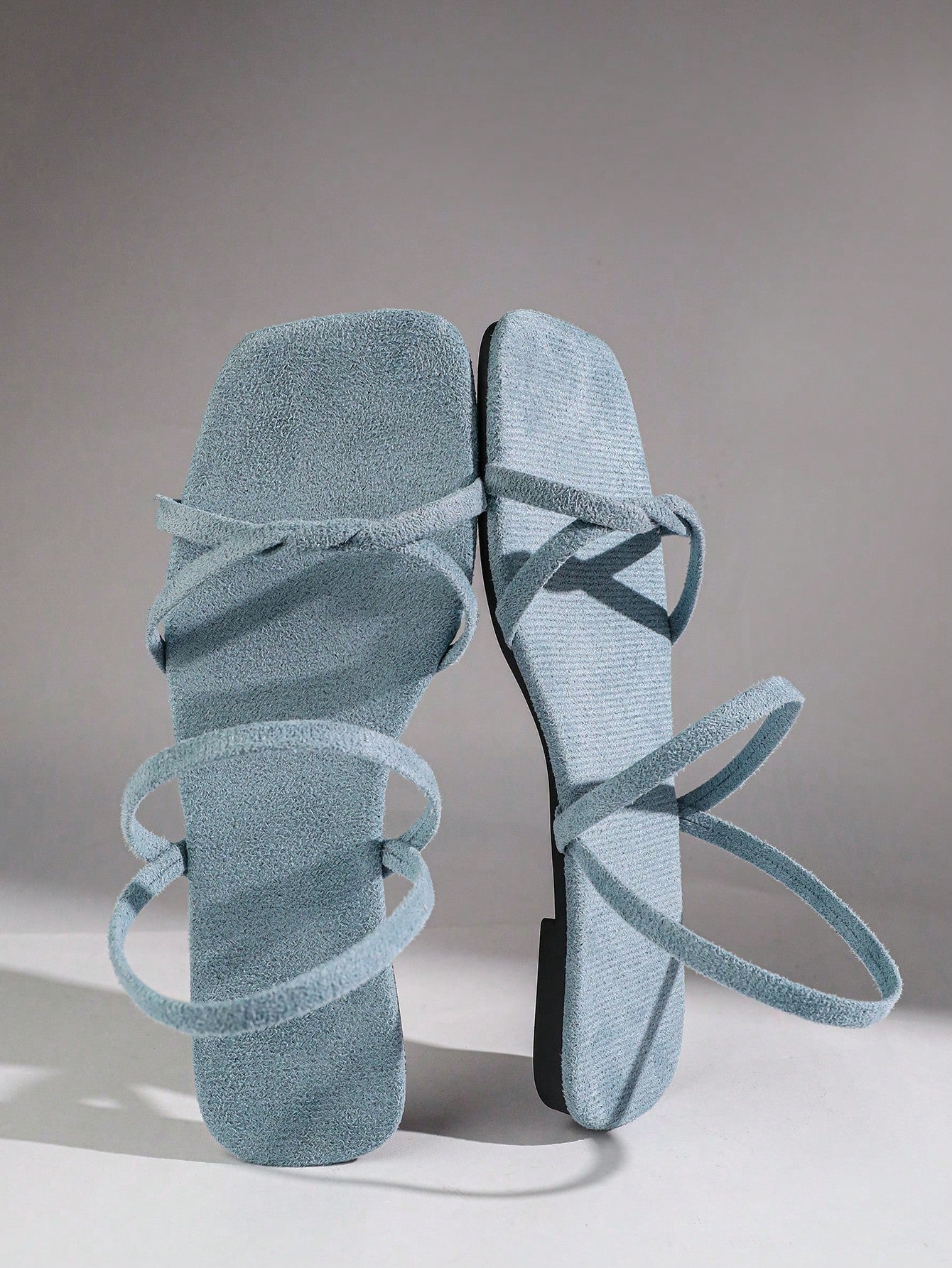 Women's flat sandals with a square open toe, crisscross front straps, and an elastic ankle strap, suitable for casual summer outdoor and beach vacation wear.